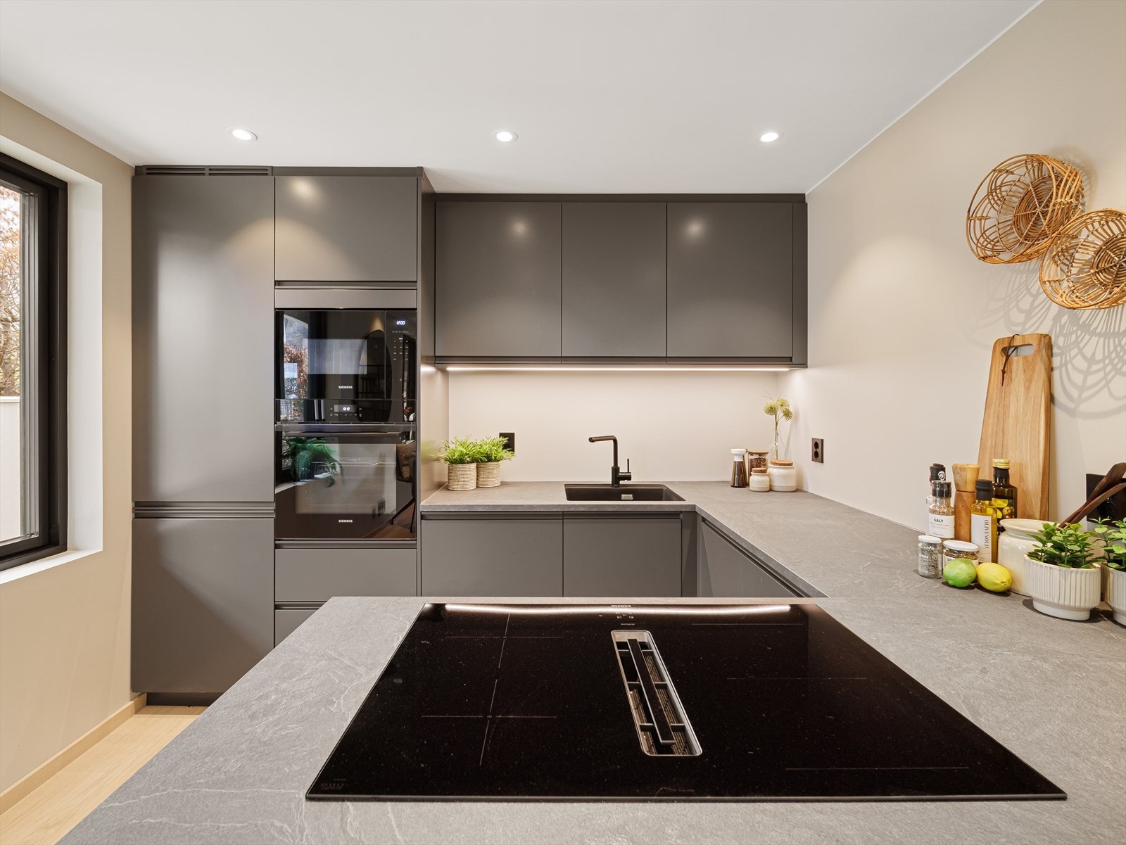 Kjøkkenet har integrerte hvitevarer som kjøl-/fryseskap og oppvaskmaskin Galleribilde