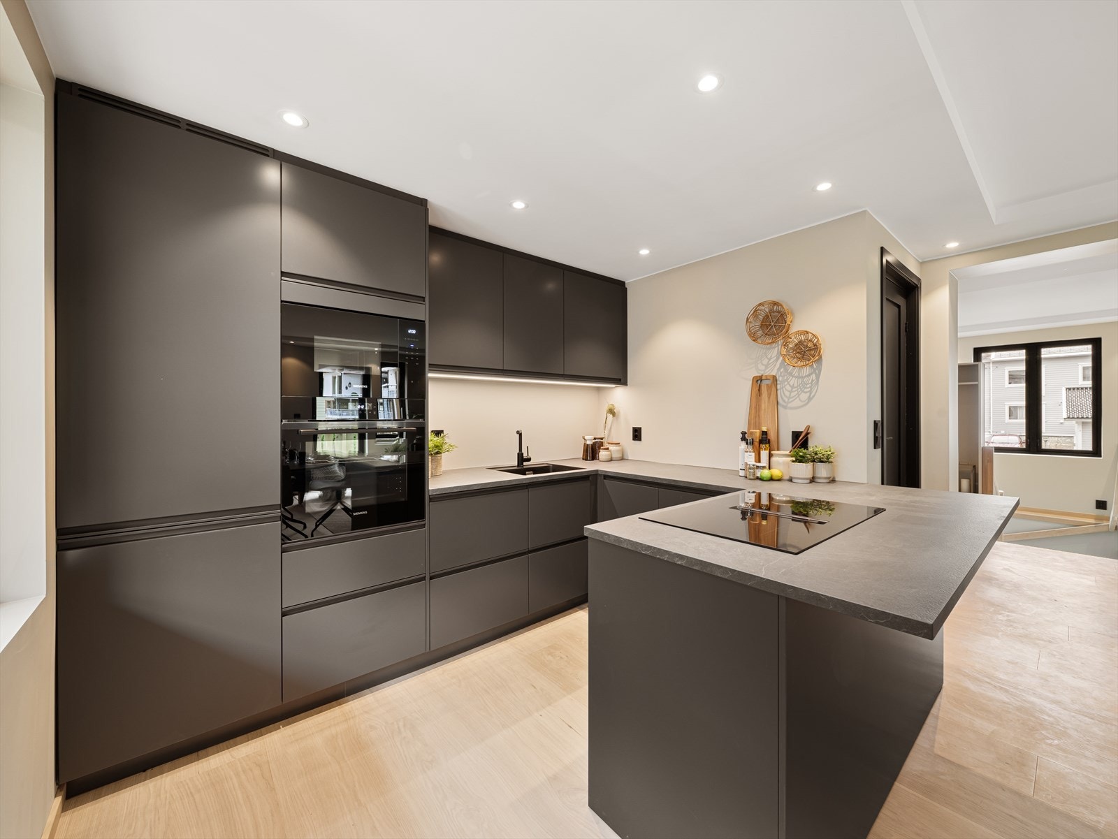 Kjøkkenet har en lekker innredning fra Drømmekjøkkenet (2026) med glatte fronter og laminat benkeplate Galleribilde