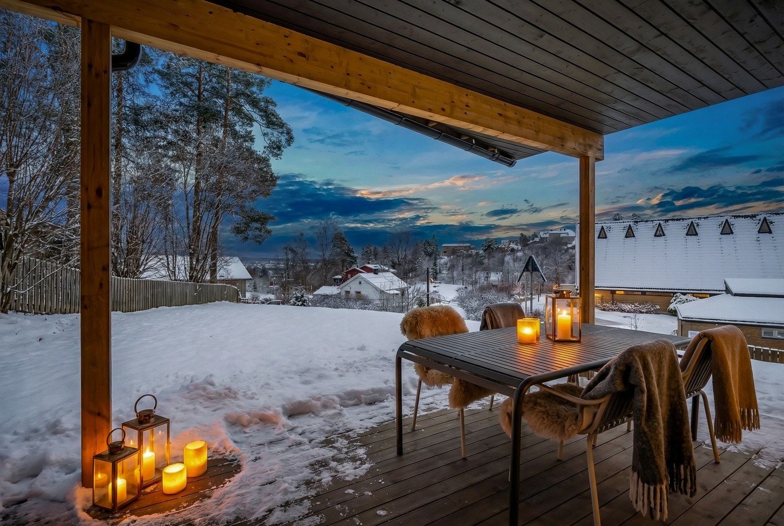En solrik terrasse med veggbelysning, overbygg og god plass til diverse utemøblement. Galleribilde