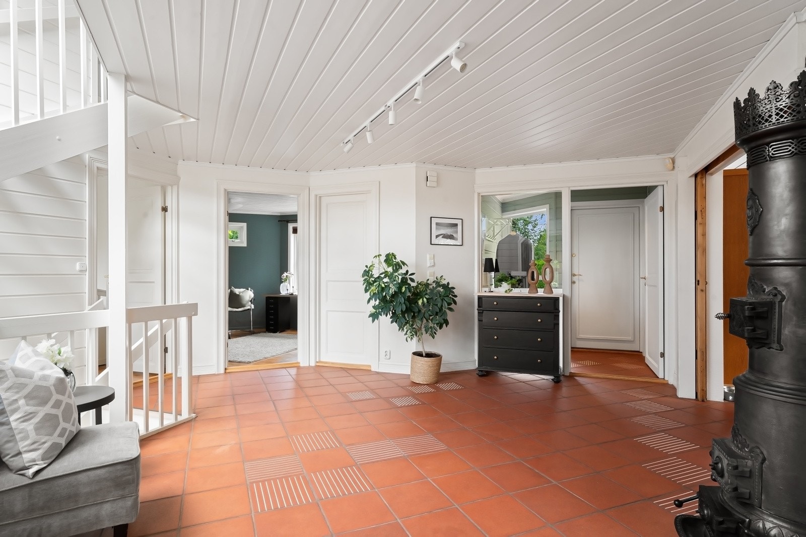 Innenfor finnes en stor, luftig hall med hvitmalte vegger, terracottafargede gulvfliser og vakker rundovn i støpejern. Galleribilde