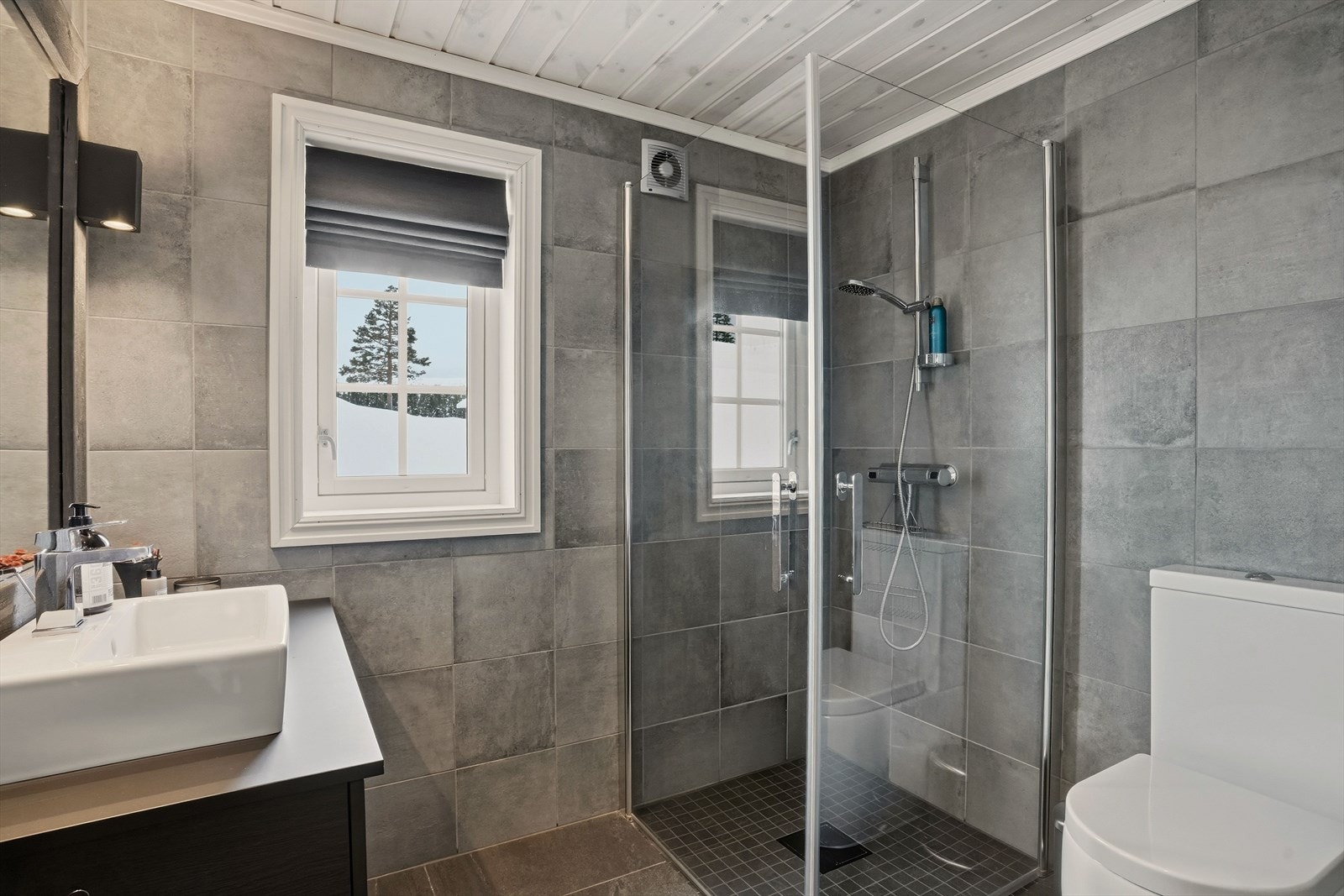 Bad nr. 2 (med adkomst fra gang/entré) inneholder servant i skuffeseksjon. toalett og dusj på vegg med glassdører. Galleribilde