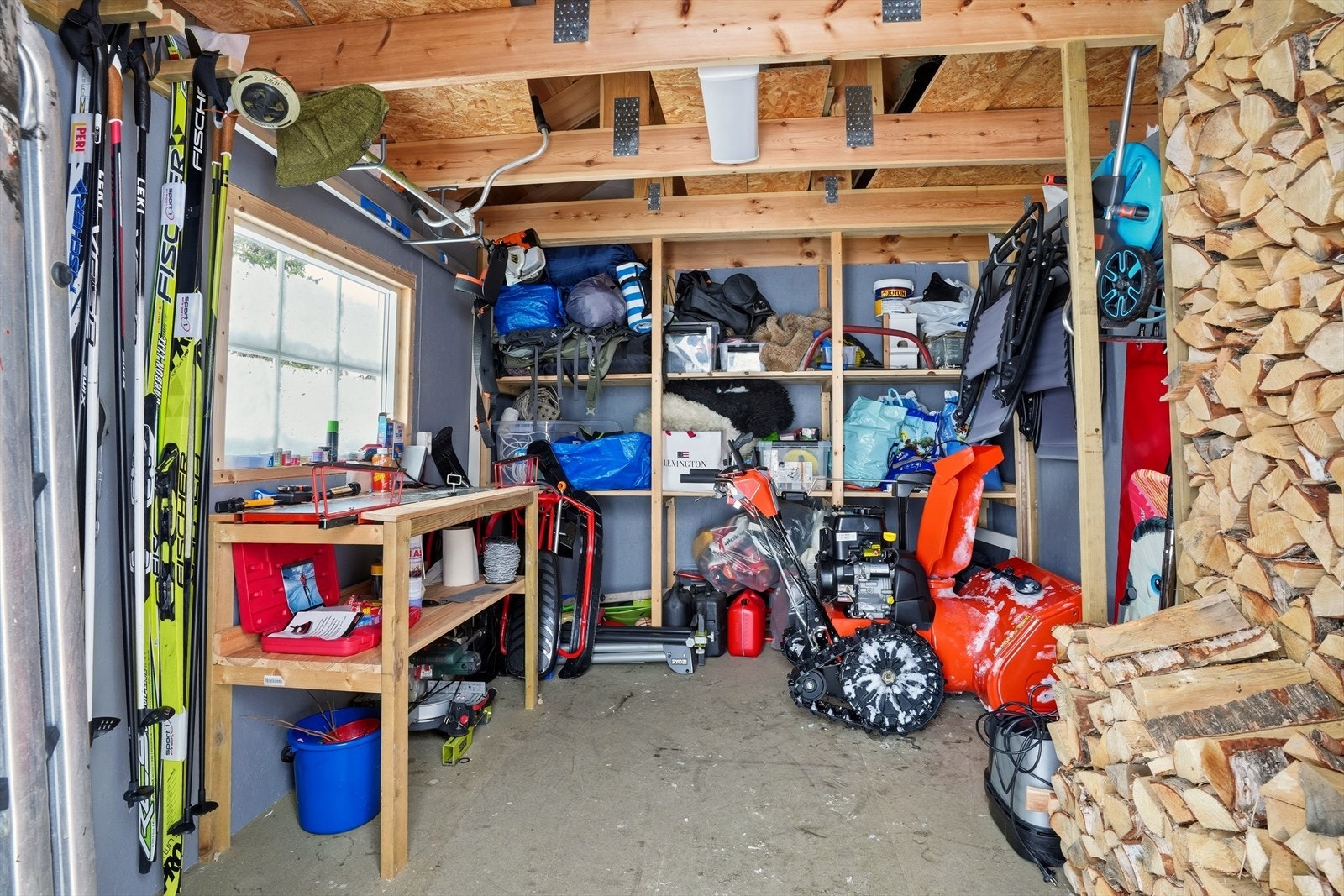 Innholdsrik sportsbod med lagerhyller og smørebenk. Galleribilde