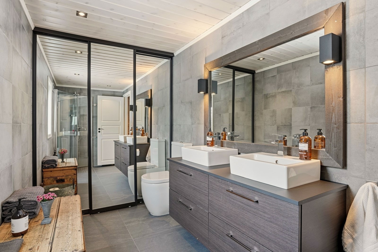 Hovedbadet inneholder to servanter i skuffinnredning, toalett, og dusj på vegg med glassdører. Skyvedørsgarderobe med speildører som dekker vaskemaskin og tørketrommel. Galleribilde