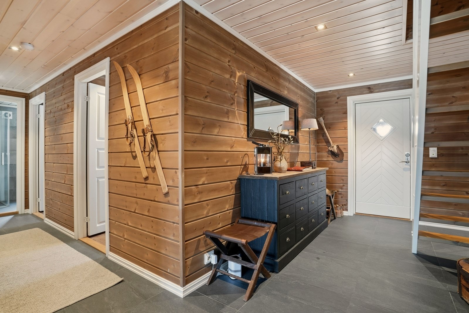 Romslig gang/entré med flislagt gulv. Trapp opp til hems med loftstue og ytterligere sengeplasser. Galleribilde