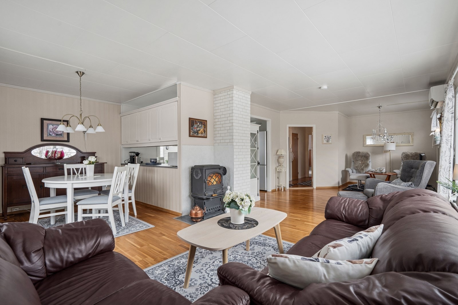 Vinkelformen på stuen gjør det enkelt å møblere i flere soner med både sofagrupper og spisebord. Galleribilde