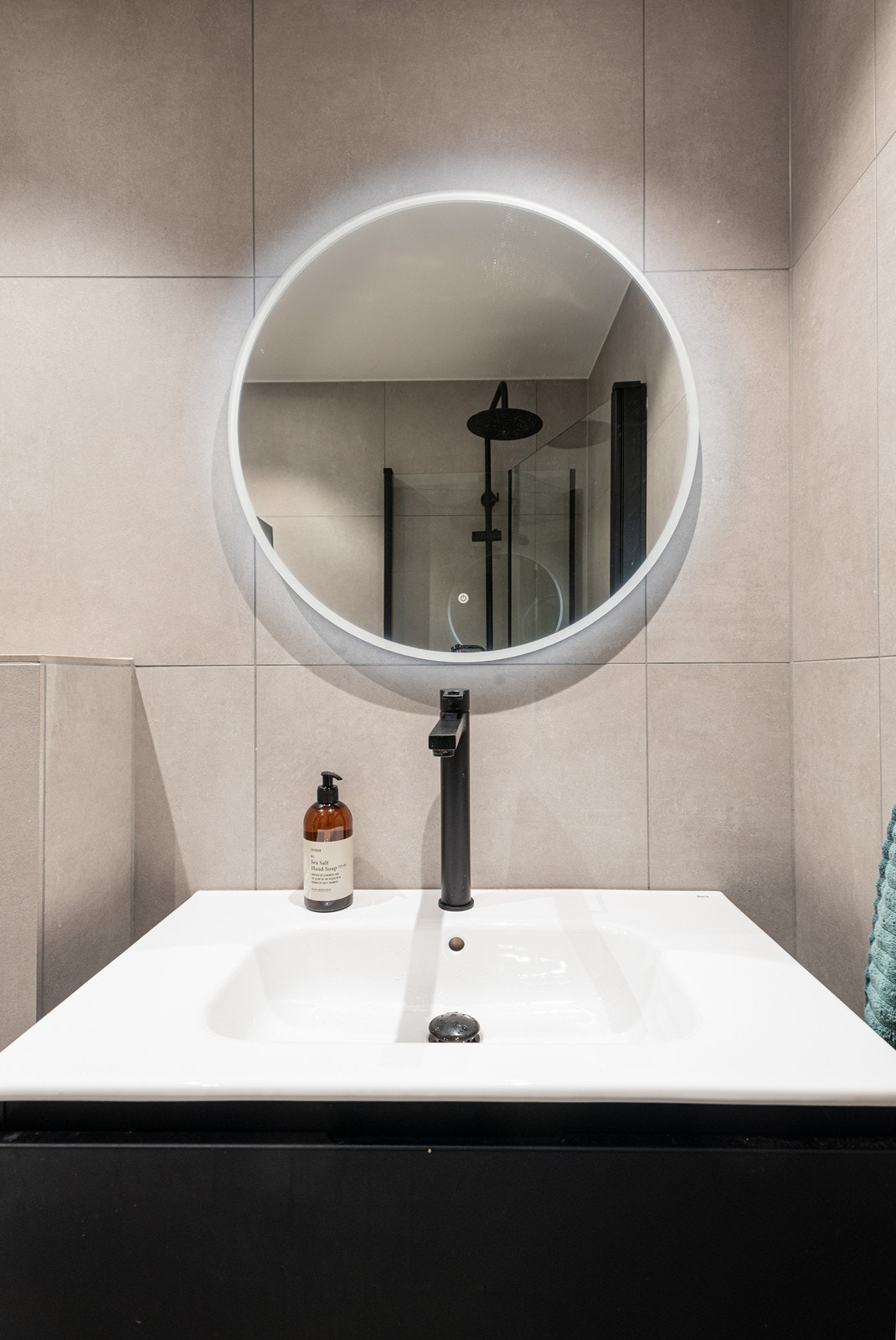 Baderomsinnredning bestående av dusjhjørne, innfellbare dusjdører, servant, servantskap og veggmontert wc Galleribilde