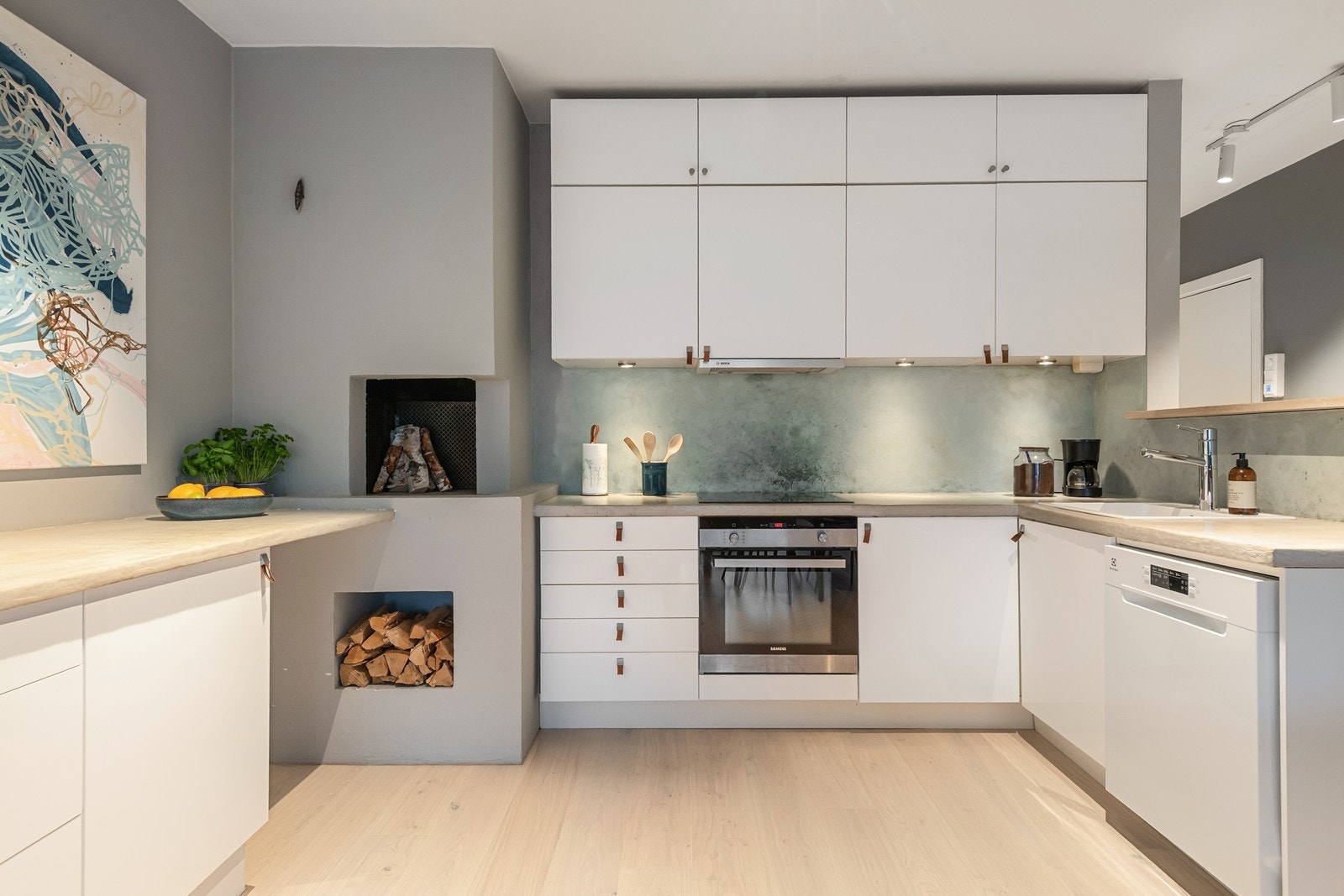 Kjøkkeninnredning med slette fronter og støpt benkeplate med nedfelt koketopp og oppvaskkum av komposit Galleribilde