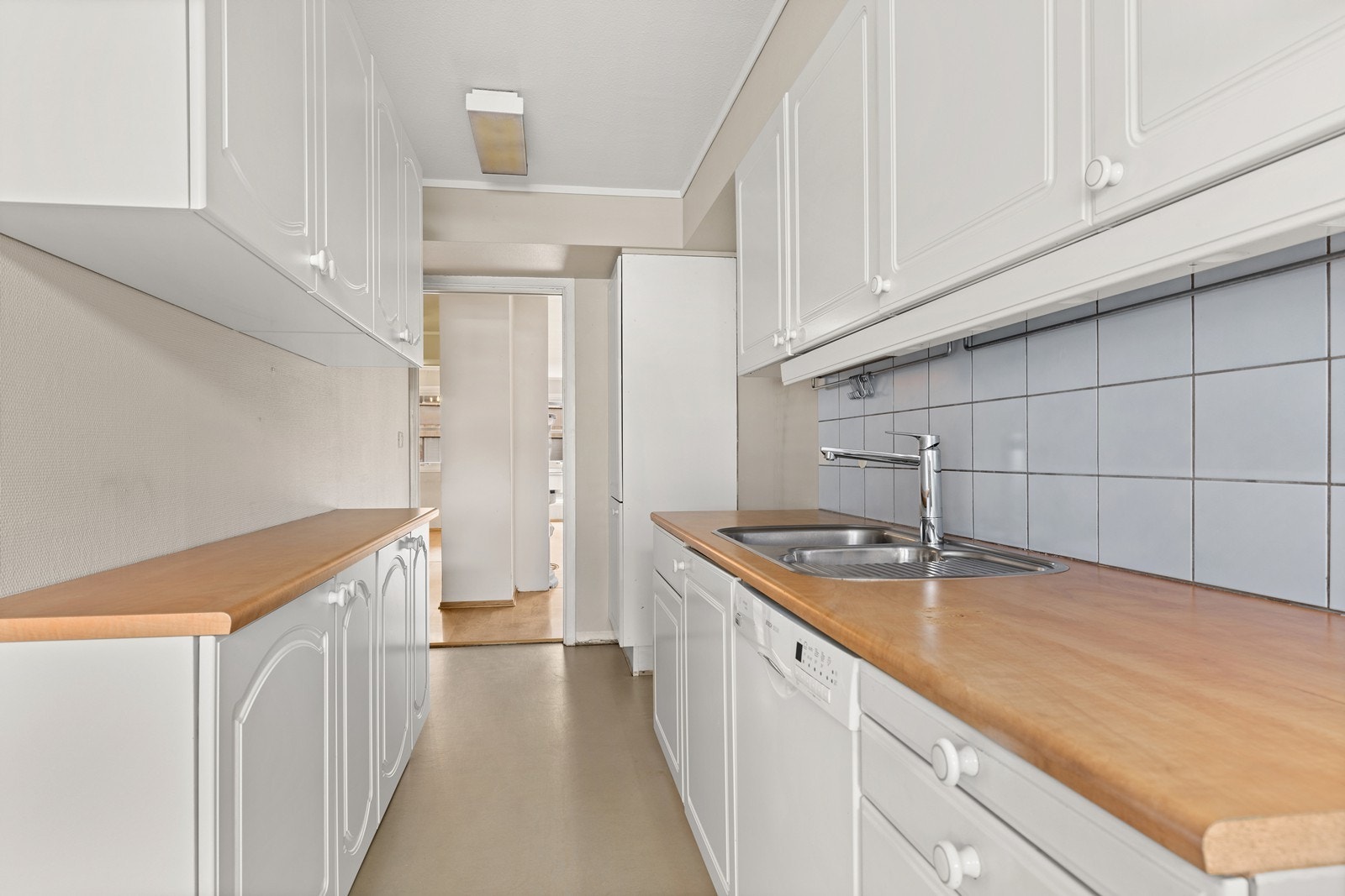 Kjøkkenet har innredning med profilerte fronter. Benkeplaten er av laminat med nedfelt stålkum. Galleribilde