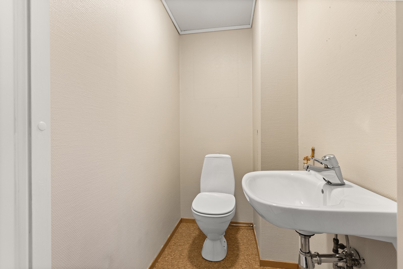 Praktisk toalettrom utstyrt med servant og toalett. Galleribilde