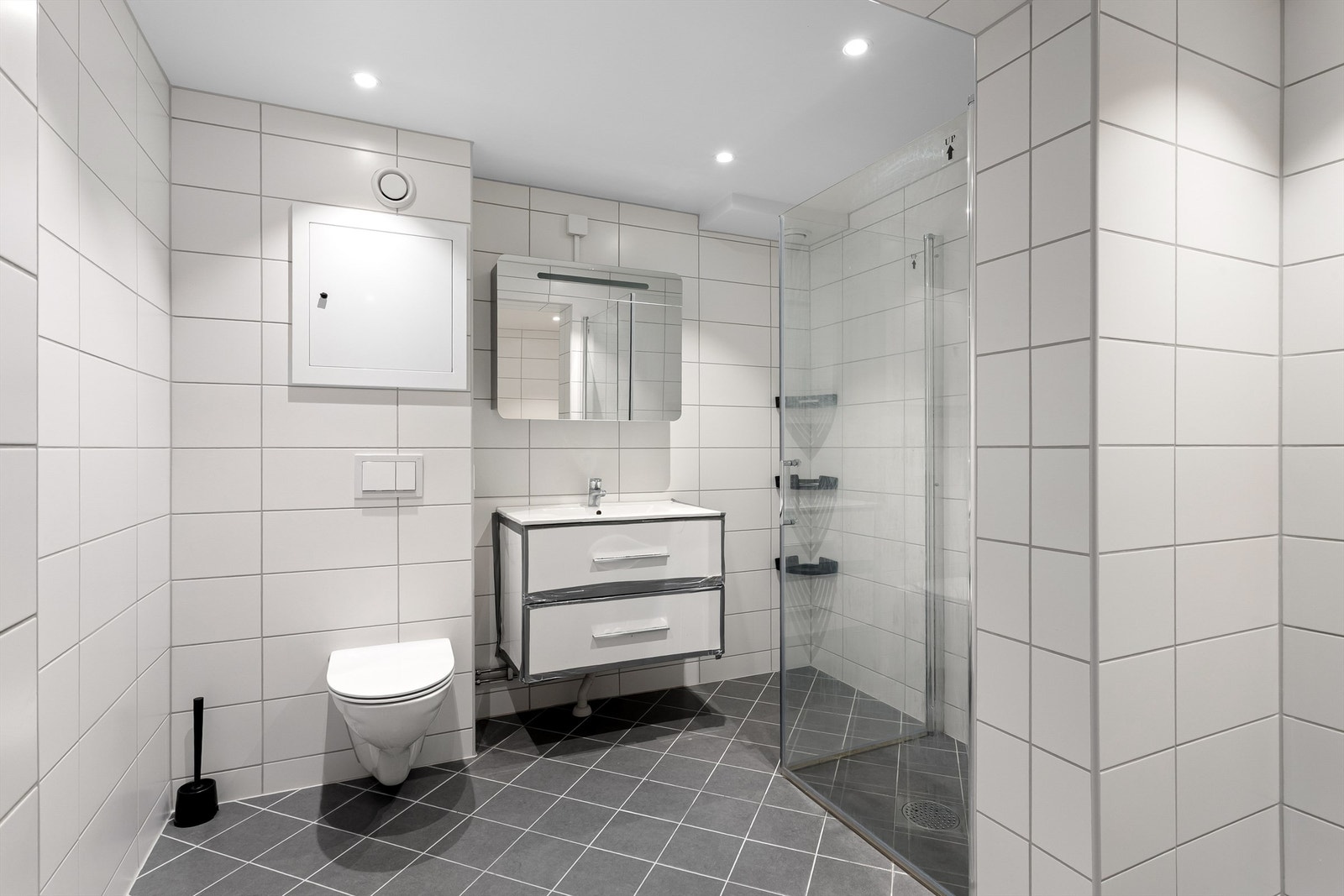 Badet er utstyrt med vegghengt toalett, servant i innredning og speilskap. Galleribilde