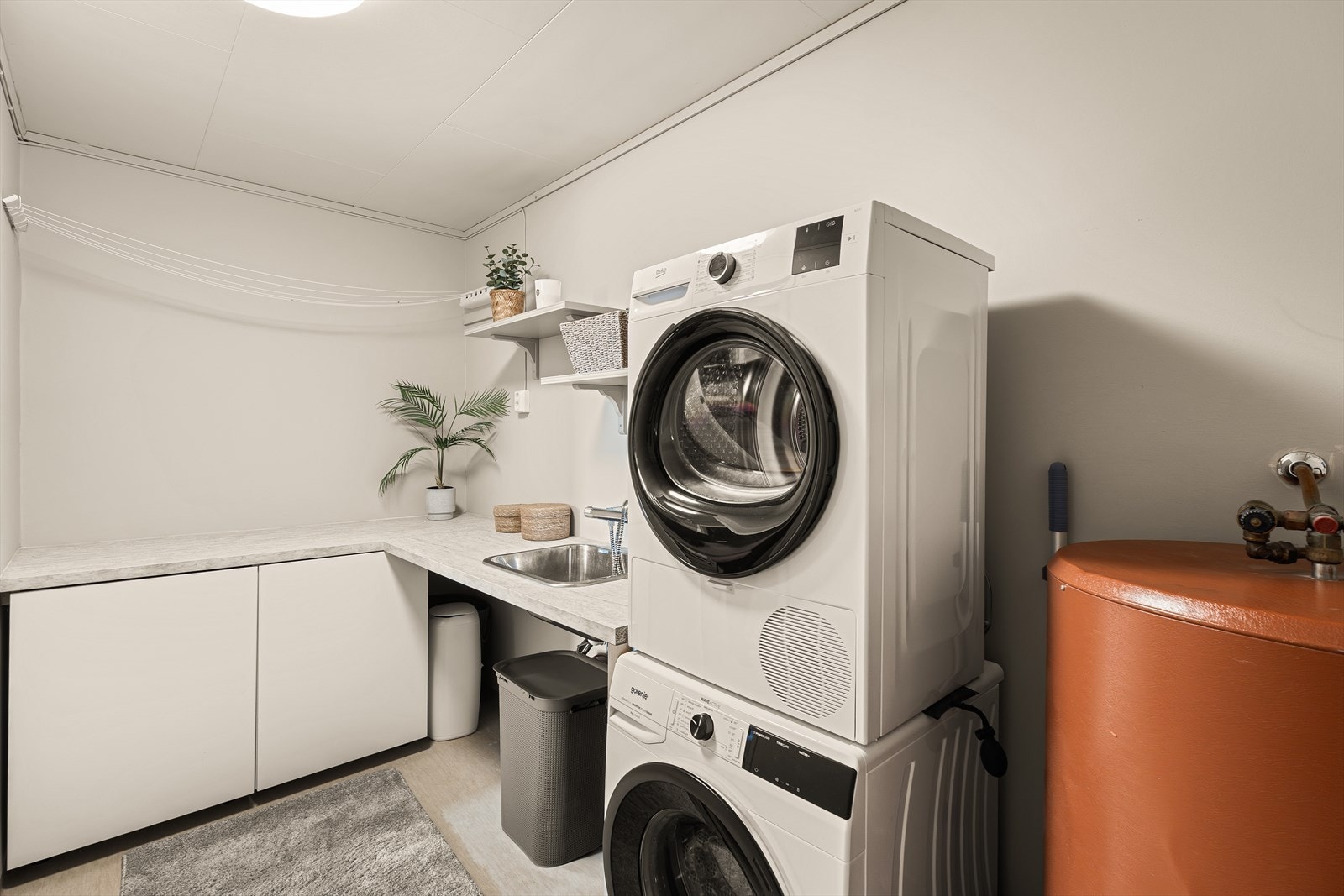 Like ved badet finner man et separat vaskerom av god størrelse. Rommet er innredet med utslagsvask, varmtvannsbereder og opplegg til vaskemaskin. Galleribilde
