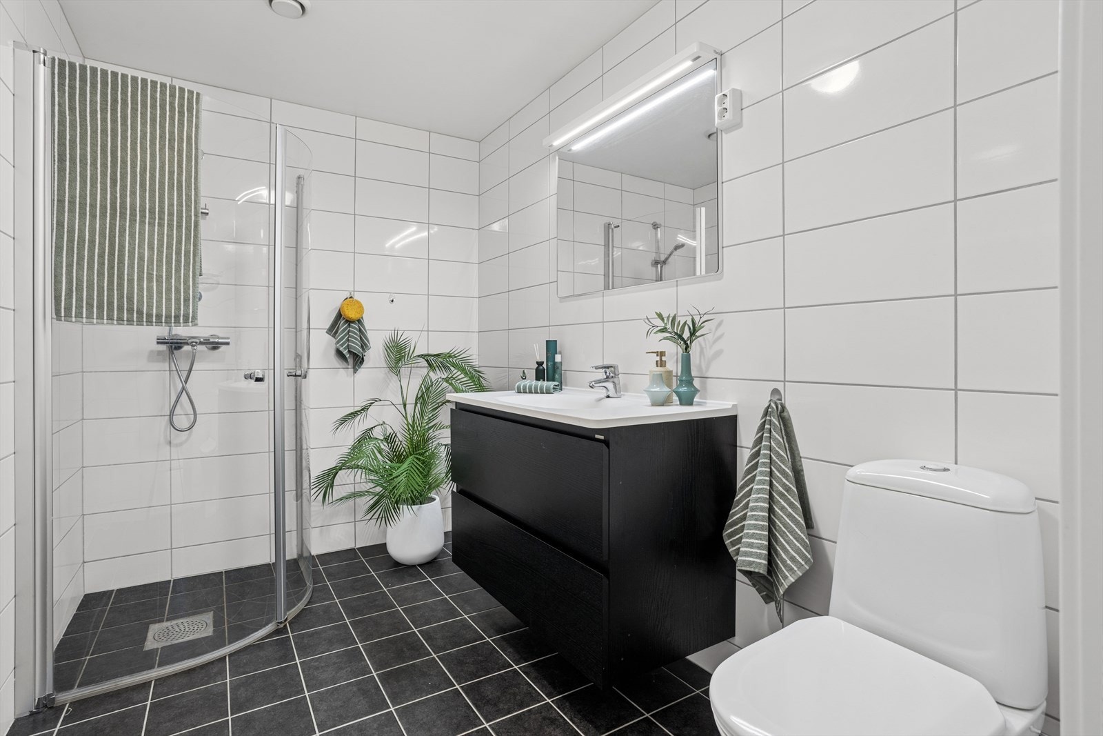 Baderomsinnredning med tidløse fliser på vegger og gulv, utstyrt med vannbåren gulvvarme Galleribilde