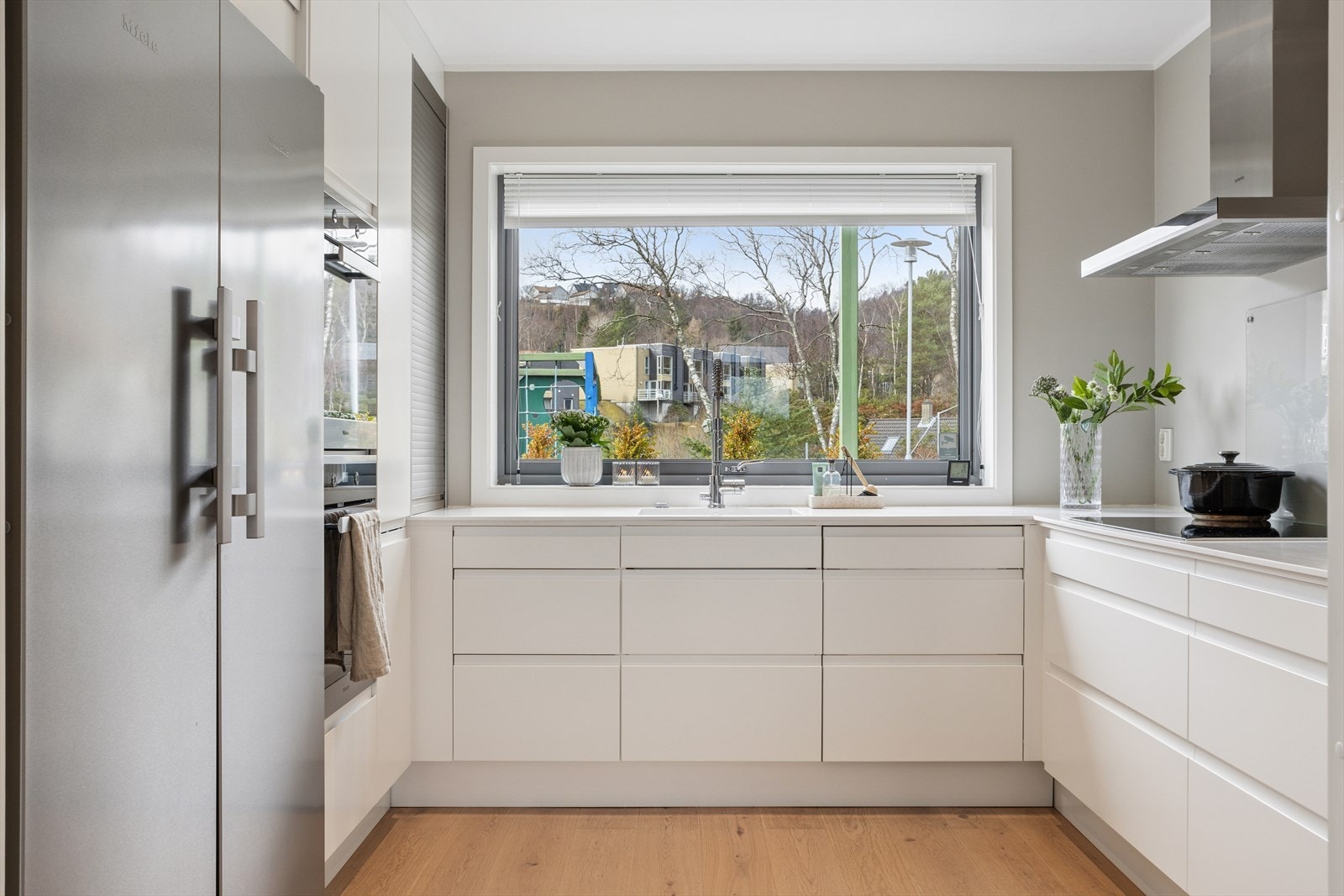 Her er det godt med benke- og skapplass som gjør kjøkkenet praktisk i bruk. Et stort vindu sørger for gode lysforhold og inviterer inn den flotte utsikten og fargene fra naturen. Galleribilde