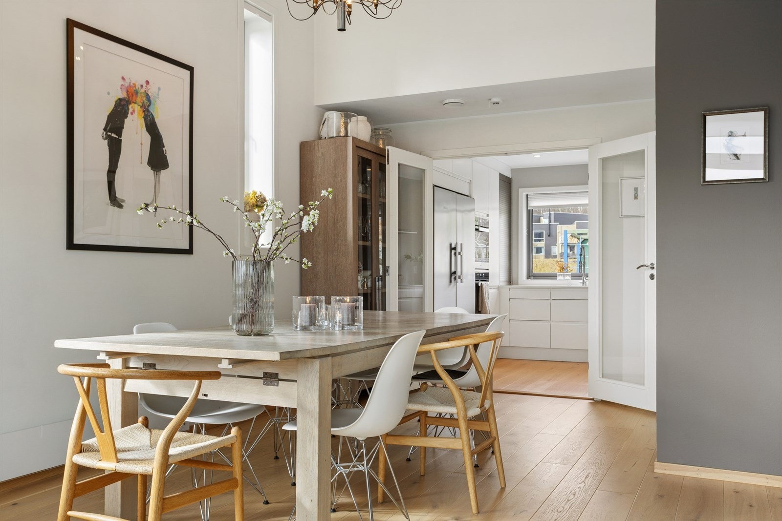 De doble glassdørene mellom stuen og kjøkkenet skaper en elegant og fleksibel rominndeling. Når de står åpne, bindes rommene sømløst sammen og gir en sosial og luftig planløsning, perfekt for selskap og hverdagsliv. Galleribilde