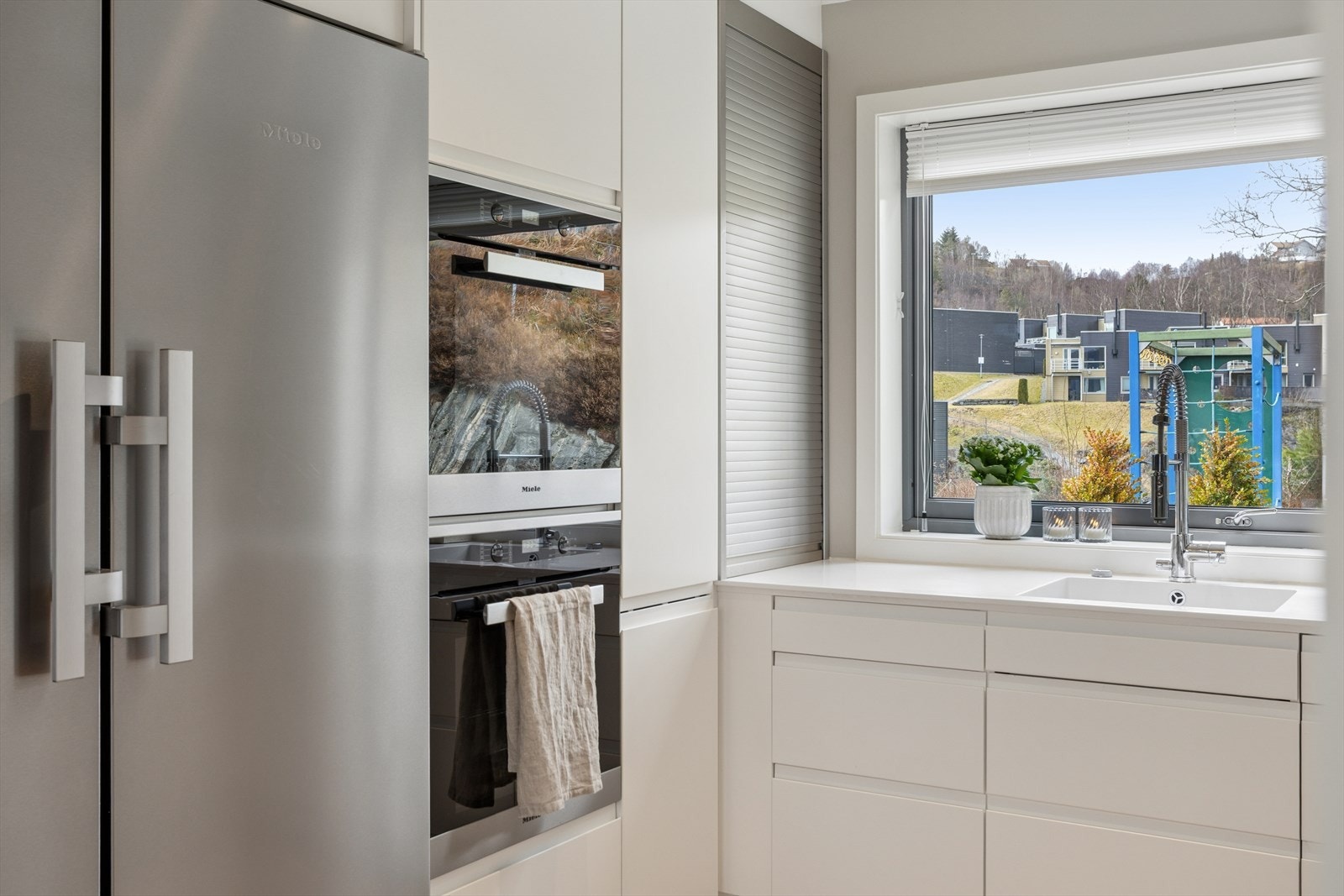 Kjøkkenløsningen er tilpasset for den som setter pris på kvalitet og funksjonalitet, med blant annet to stekeovner, induksjonstopp, vinskap og et kjøle-/fryseskap i børstet stål. Galleribilde