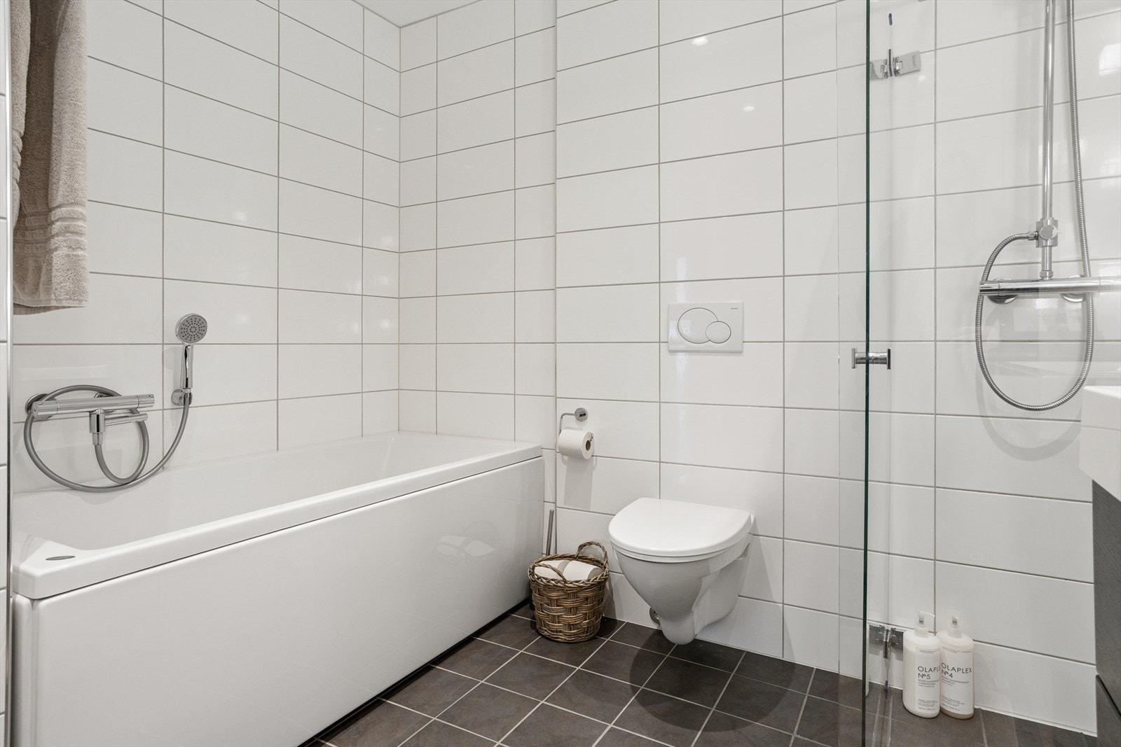 Rommet er innredet med vegghengt toalett, dusj med glassfoldedører, badekar og dobbel servant med møblement. I u.etg finner du også et vaskerom med utslagsvask, opplegg for vaskemaskin, varmtvannsbereder og rør-i-rør skap, alt med fliser og varmekabler. Galleribilde