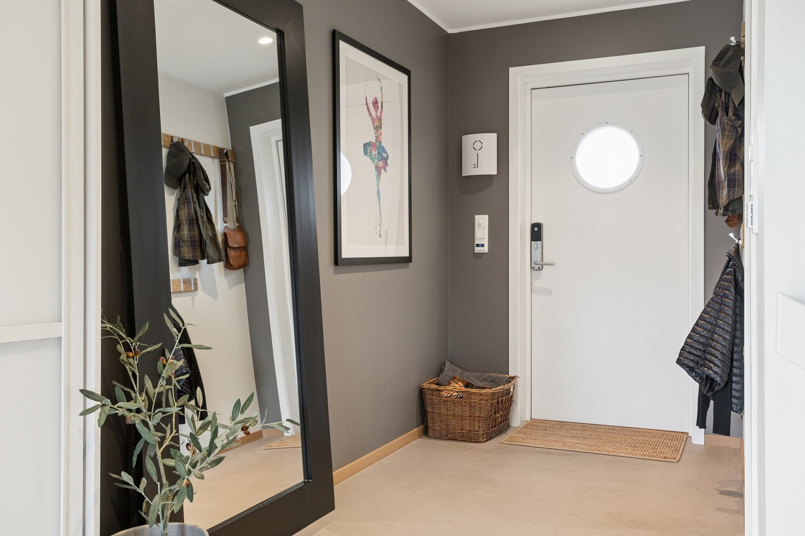 Ved inngangen møtes du av en lys og romslig entré med microsement og varmekabler i gulvet som gir en lun og behagelig velkomst. Her er det god plass til yttertøy og oppbevaring i en praktisk skyvedørsgarderobe. Galleribilde