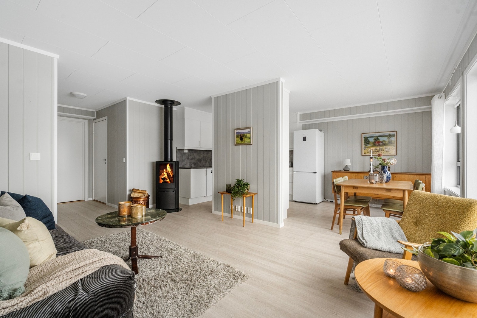 Romslig stue med peis og plass til spisebord. Åpen løsning mot kjøkken gir god utnyttelse av arealet og er perfekt når du har gjester til bords. Galleribilde