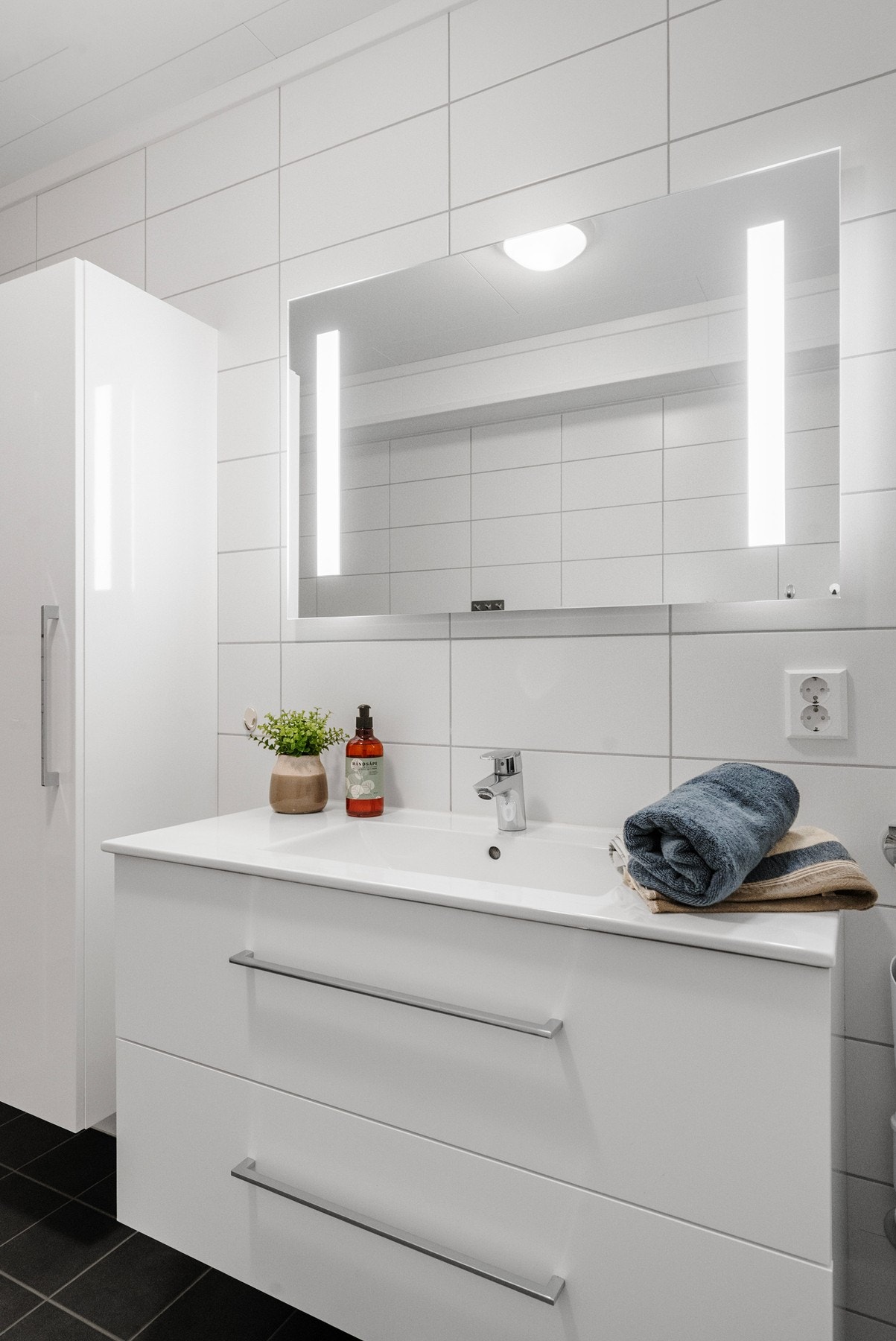 Moderne bad med praktisk servant og speilskap. Opplegg og plass for vaskemaskin. Galleribilde