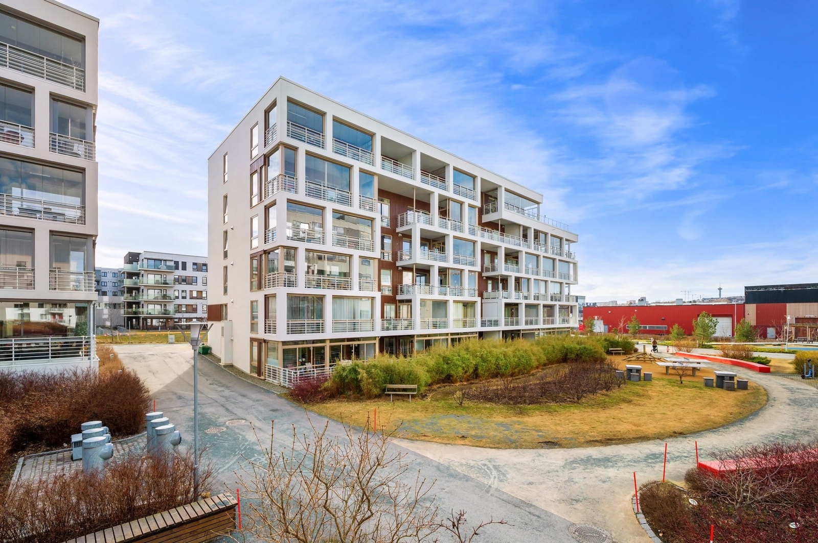 Mellom blokkene er det flere plenlagte fellesområder, men sitteplasser, buskevekster og utstyr for utendørsaktiviteter. Galleribilde