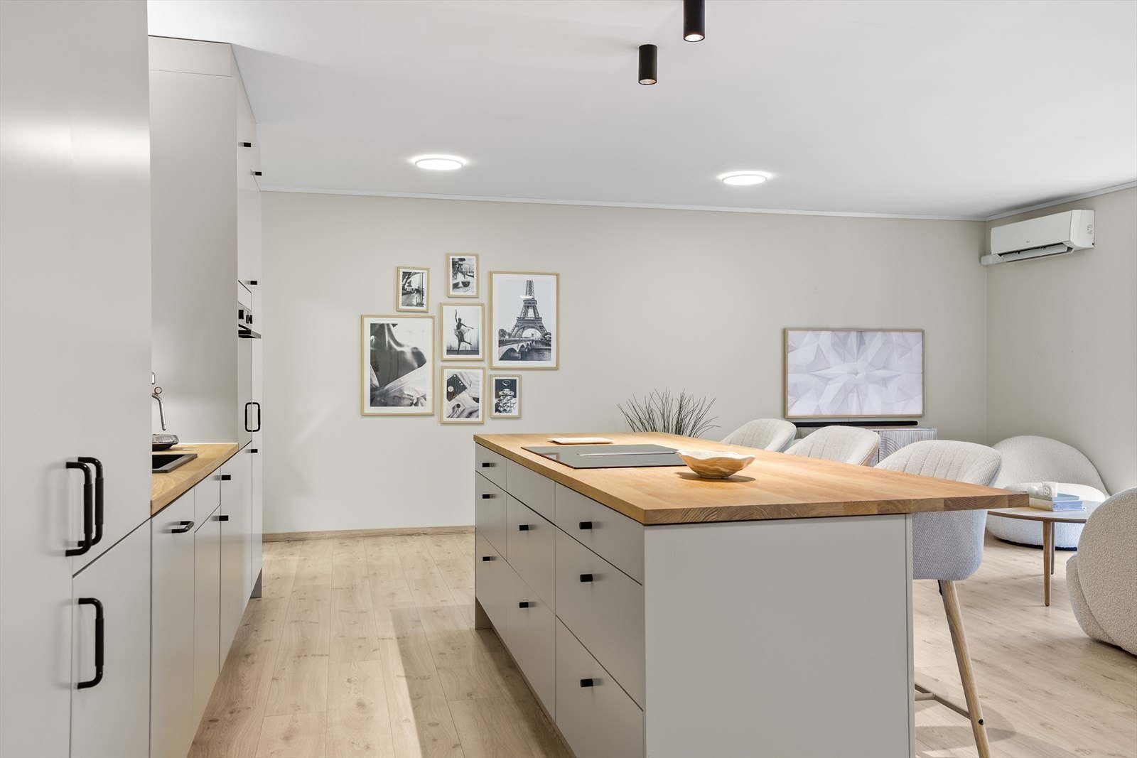 Kjøkkenet har også en romslig og praktisk kjøkkenøy med nedfelt platetopp, noe som gjør matlagingen både effektiv og sosial. Øya gir rikelig med ekstra arbeidsflate og fungerer samtidig som et naturlig samlingspunkt i romme Galleribilde