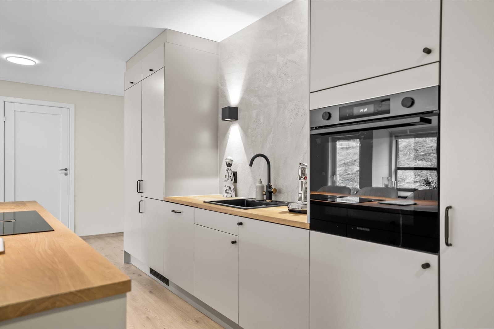 Kjøkkenet er utstyrt med integrerte hvitevarer som komfyr, oppvaskmaskin, platetopp og kjøl/fryseskap. De integrerte løsningene bidrar til et helhetlig og eksklusivt uttrykk, samtidig som de gir en praktisk og effektiv kjøkkenhverdag. Galleribilde