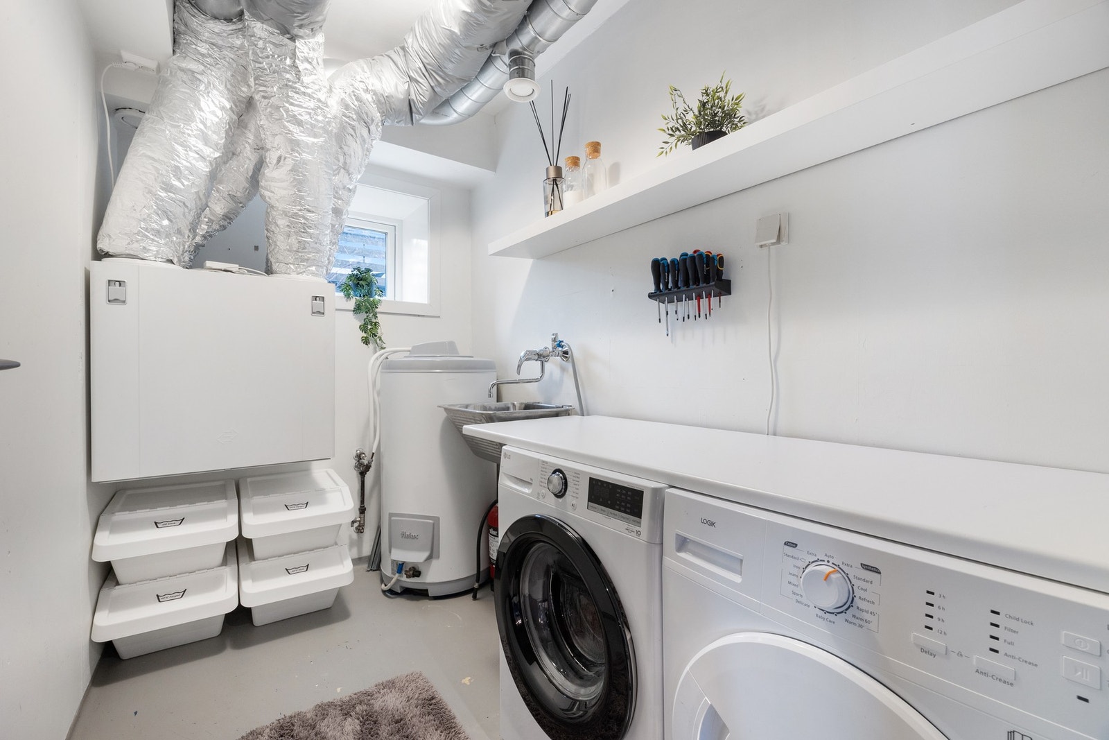 Separat vaskerom med god plass til vaskemaskin, tørketrommel og ulike oppbevaringsløsninger Galleribilde
