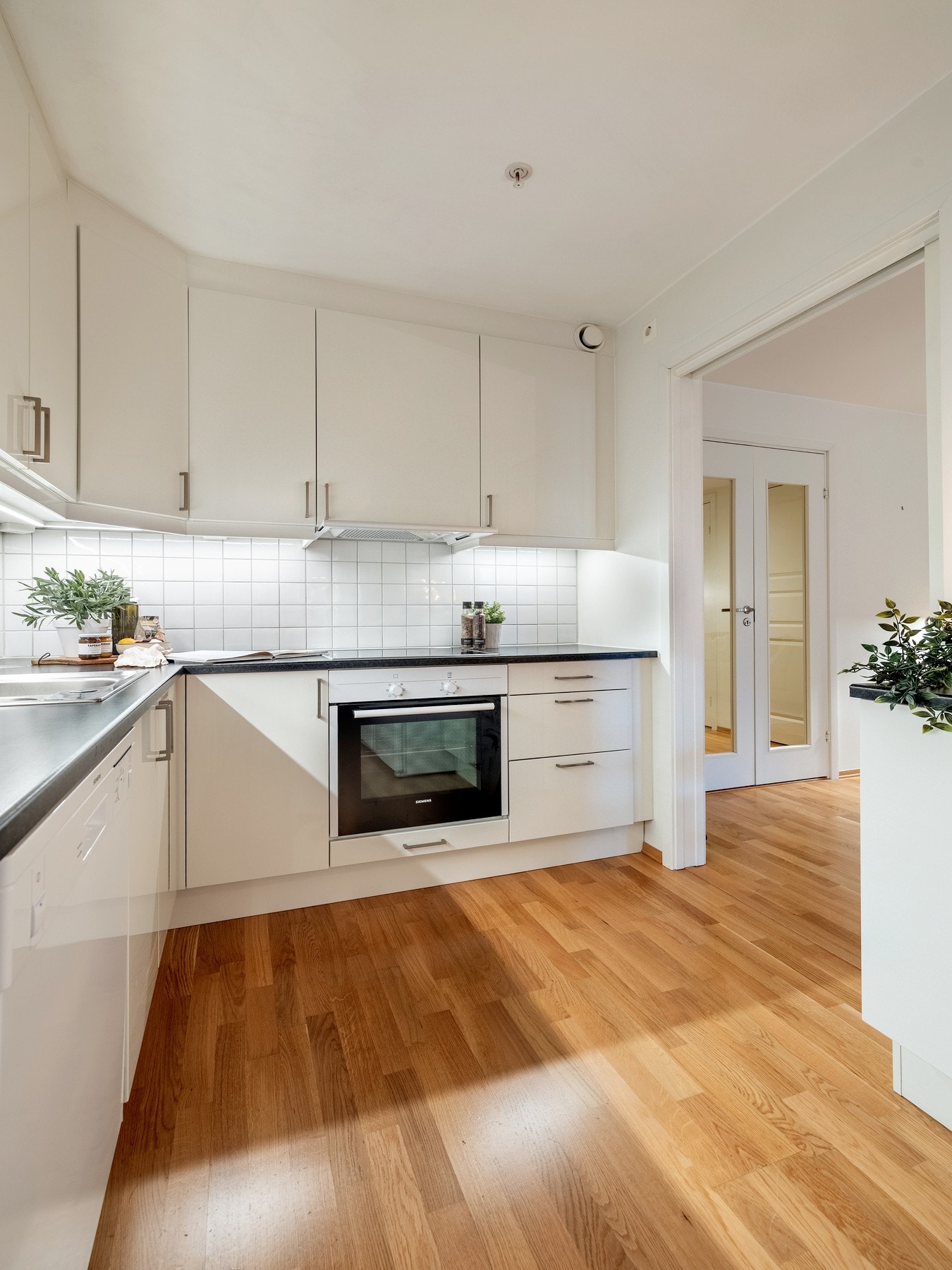 Kjøkkenet er utstyrt med integrerte hvitevarer som induksjonstopp og komfyr, samt frittstående kjøleskap og fryseskap. Galleribilde