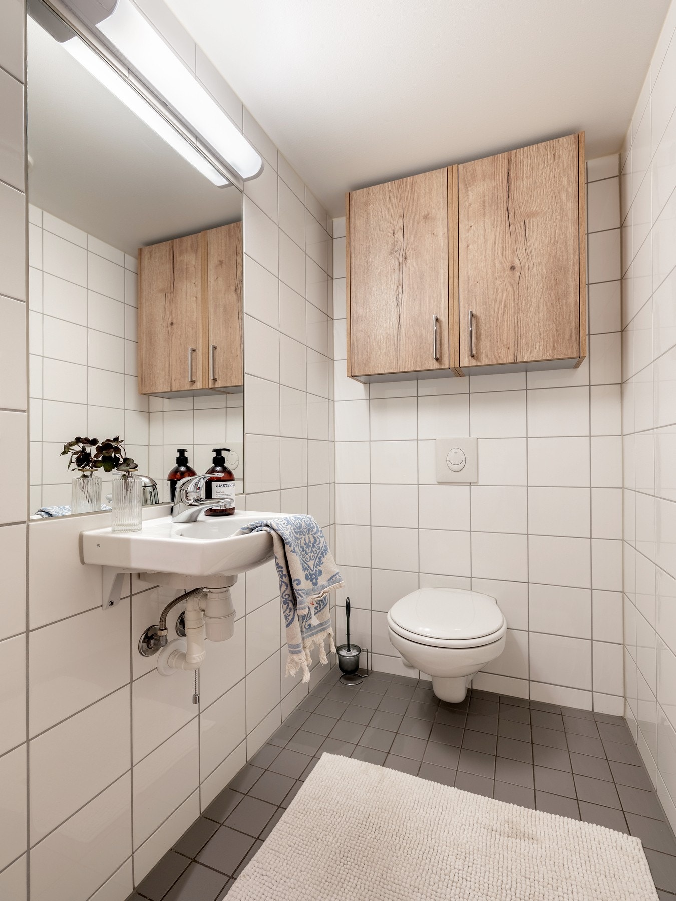 Toalettrommet har flislagte vegger og gulv med gulvvarme. Rommet er innredet med servant, overskap og vegghengt toalett. Galleribilde