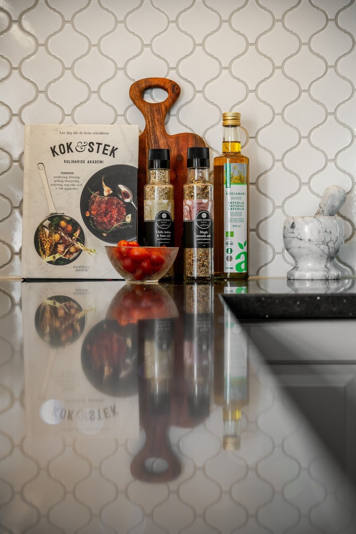 Bankeplaten er av stein, noe som gjør den slitesterk og hygienisk. Den gir et stilrent, tidløst uttrykk og tåler varme og daglig bruk godt. Den er også enkel å vedlikeholde. Galleribilde