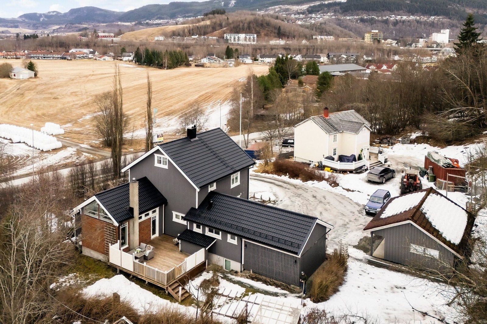 Hagen strekker seg rundt boligen og har en hyggelig bakhage med pergola, stor terrasse og plen. Hagen på forsiden av boligen er stor og frodig, med planter og huskestativ for barna. Galleribilde