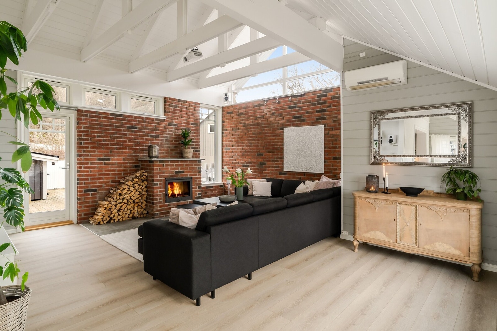 Peisestuen imponerer med høy takhøyde og en lun teglstenpeis som skaper en varm og innbydende atmosfære. Herfra har du også praktisk utgang til terrassen. Galleribilde