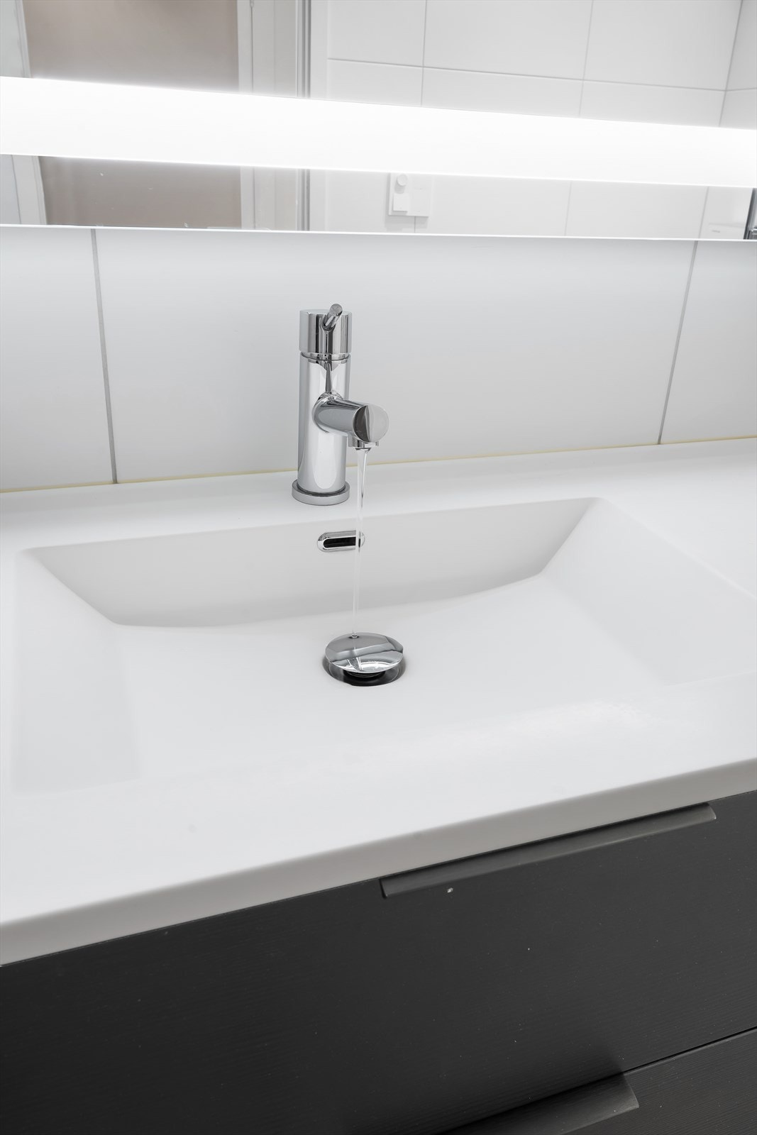 Innredningen består av underskap, servant, speil med belysning, vegghengt toalett og dusjhjørne. Galleribilde