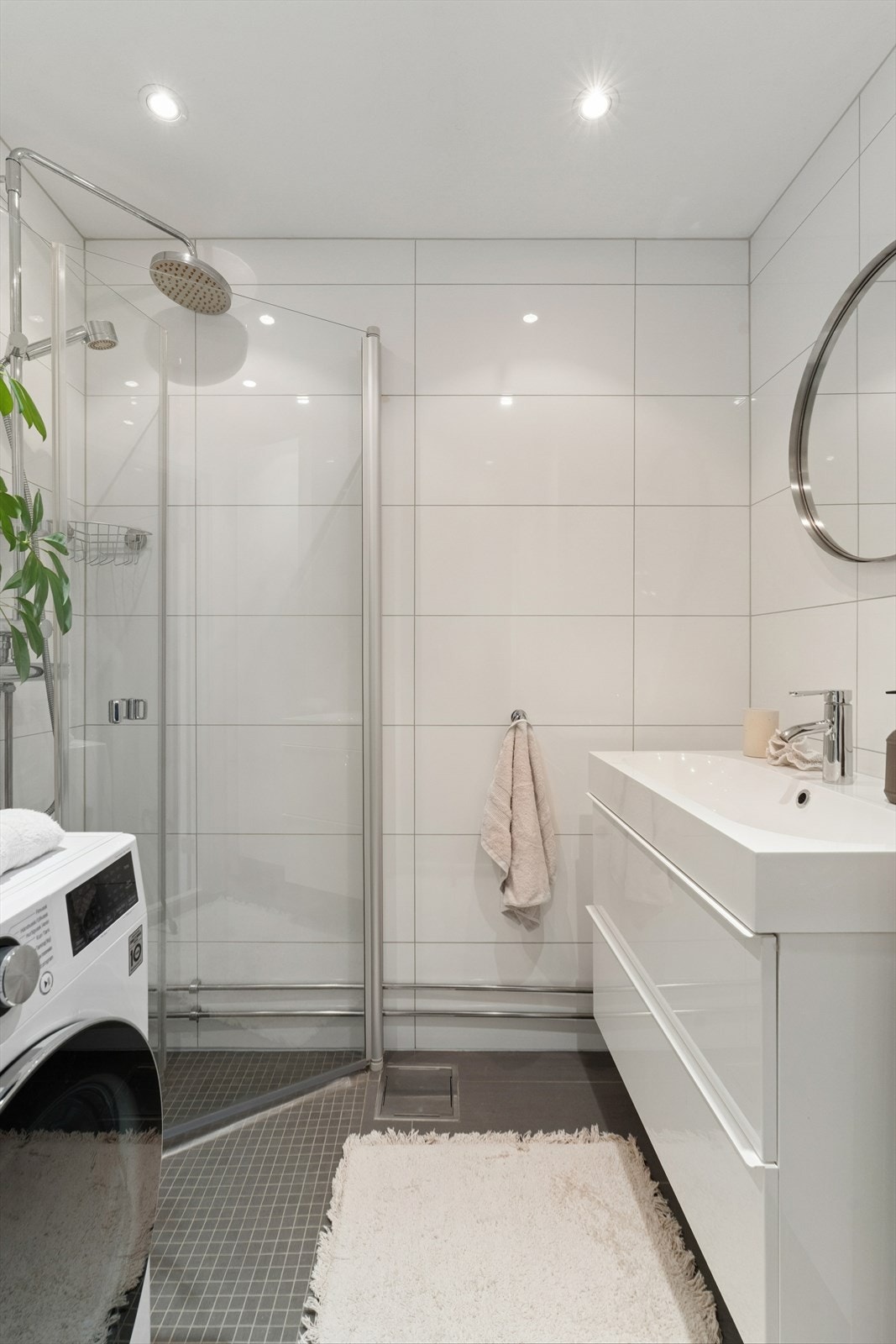 Flislagt og lyst baderom fra 2013 innredet med nedfelt servant og dusjvegger/hjørne. Downlights i himling. Galleribilde