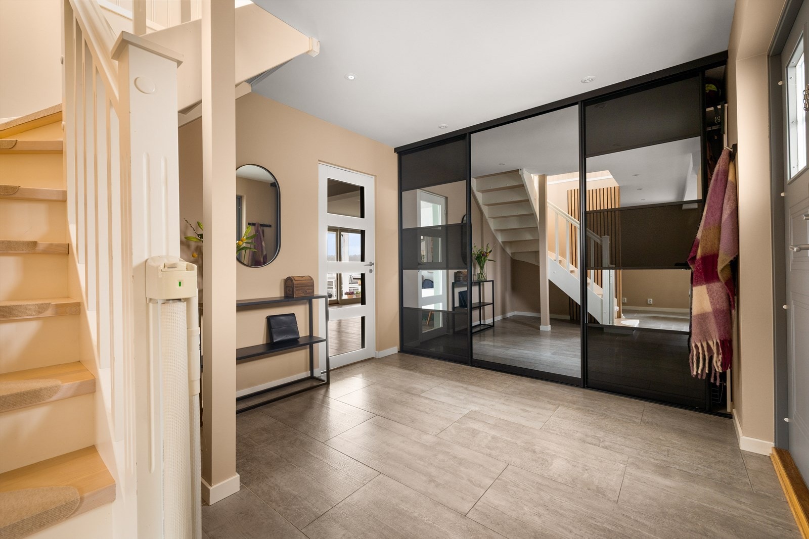 Stor skyvedørsgarderobe med speilfronter gir rikelig med oppbevaringsplass i entreen. Galleribilde