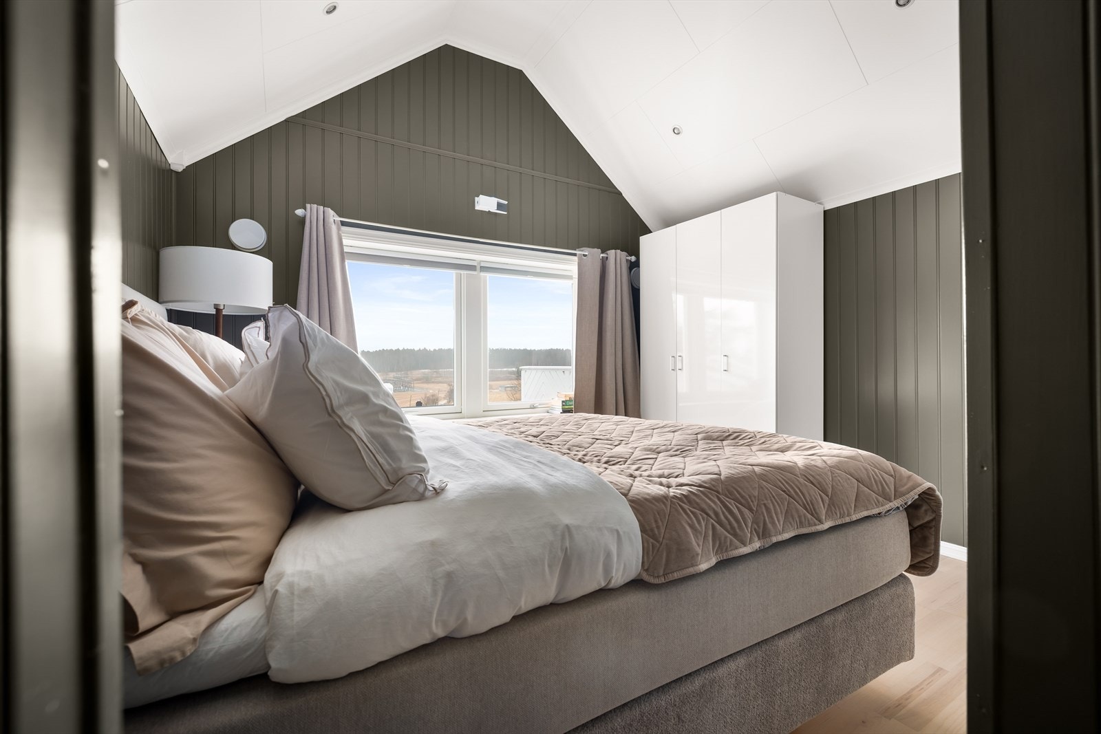 Skråtaket og den dype fargen på veggene skaper en lun og hyggelig atmosfære. Galleribilde