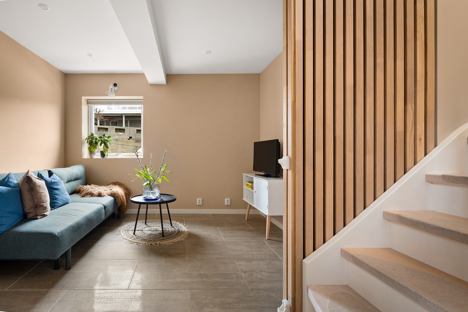 Innenfor entreen ligger en lun og koselig stue, ideell som TV-stue eller lekerom. Galleribilde