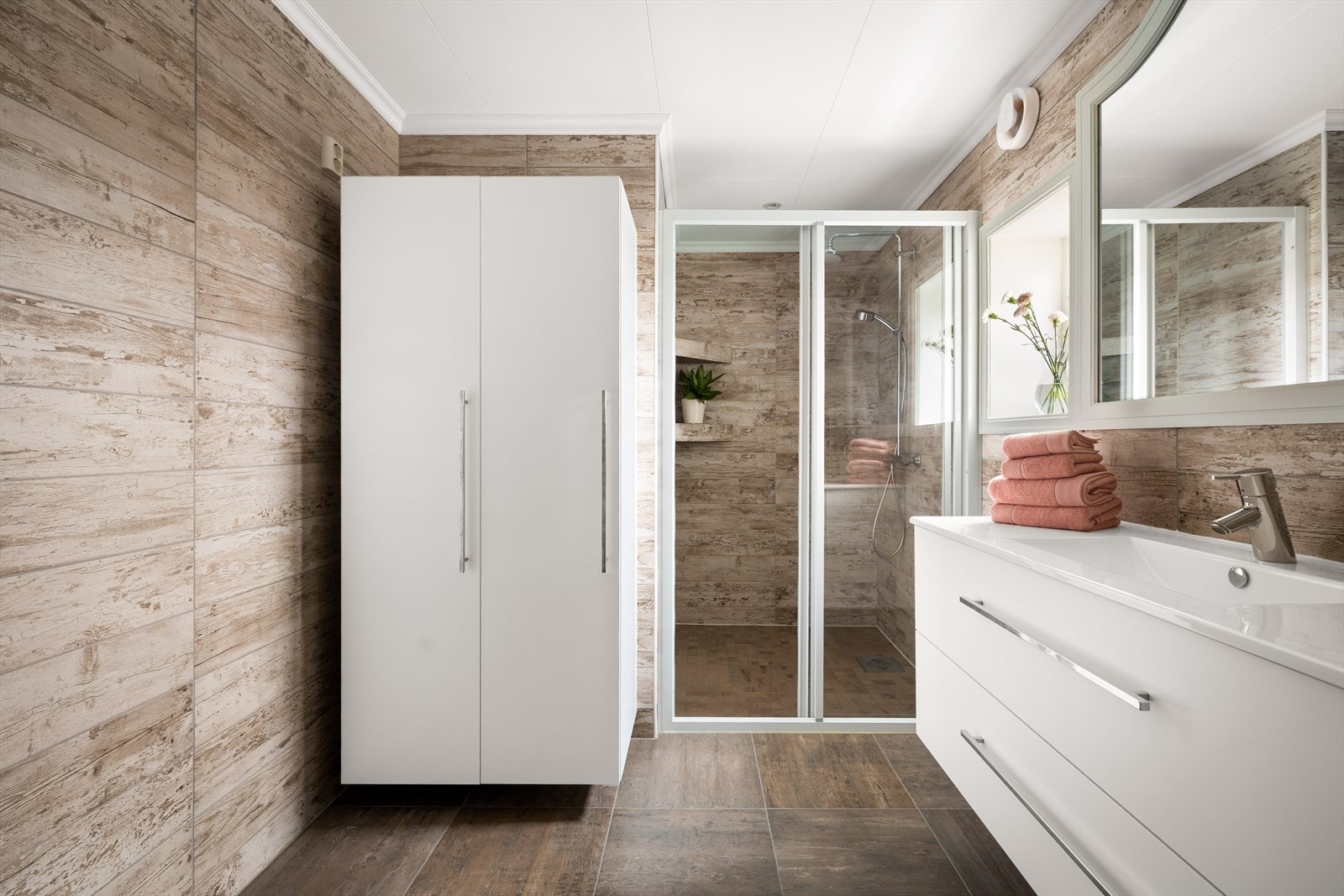 Baderomsinnredning med servant og skuffer, samt speil med belysning. Galleribilde