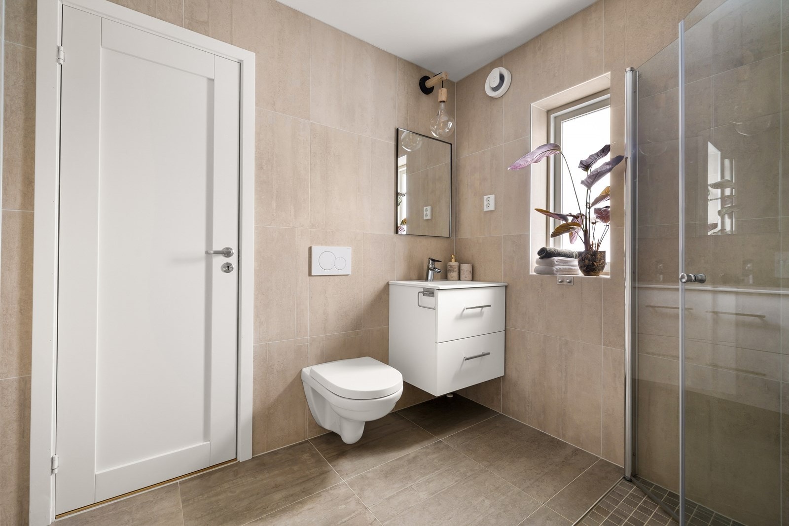 Badet er utstyrt med vegghengt toalett og servantinnredning med skuffer. Galleribilde