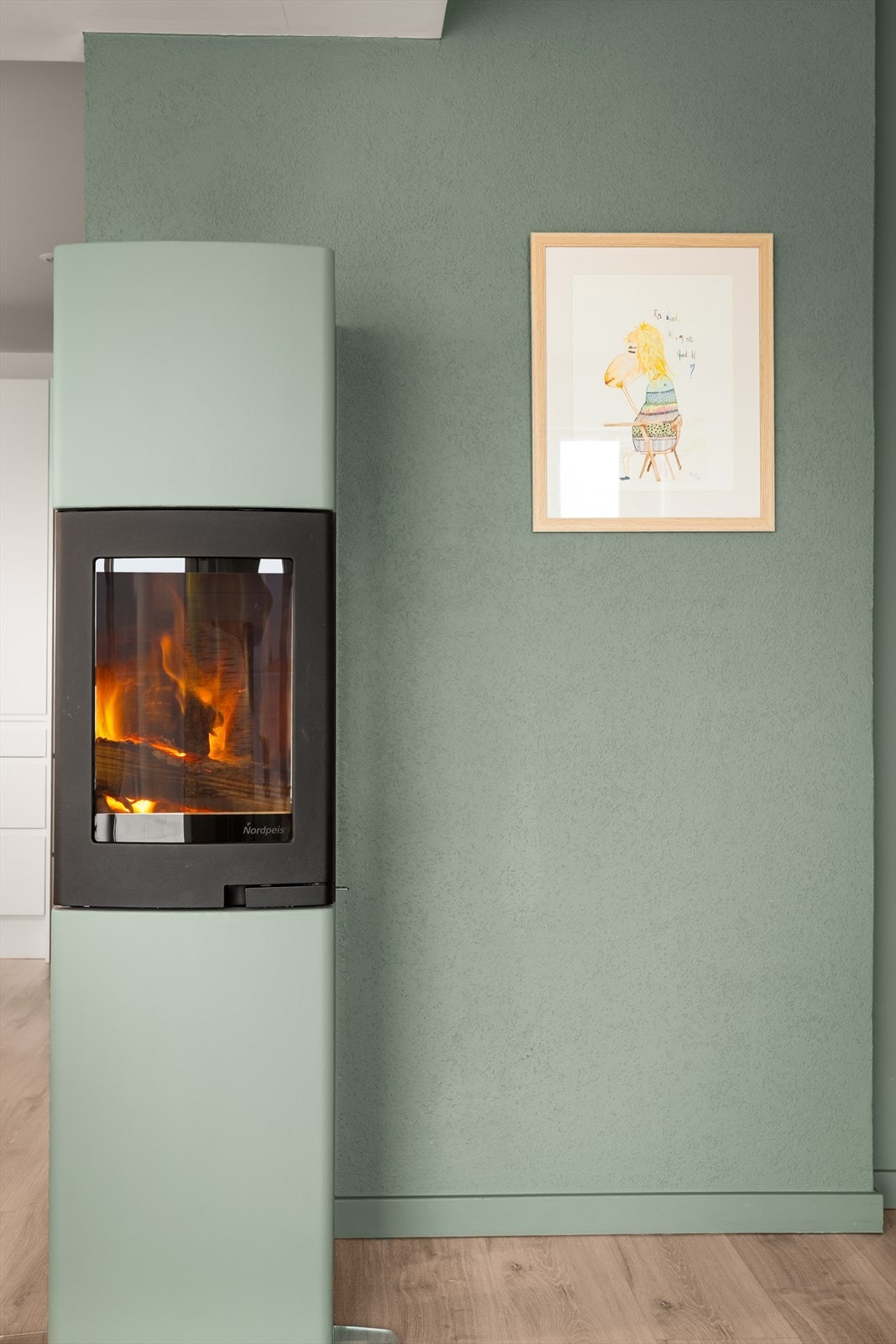 Peisovnen er et stilrent element som er sentralt plassert mellom kjøkken og stue. Galleribilde