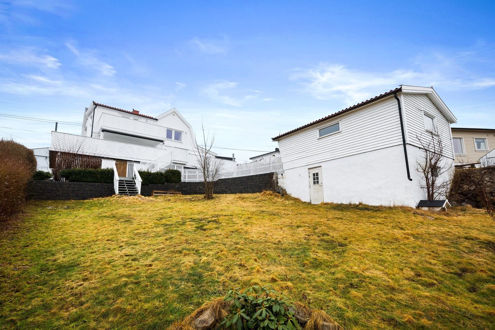 Tomten er pent opparbeidet med plen og hekk, ideelt for lek og aktivitet. Galleribilde