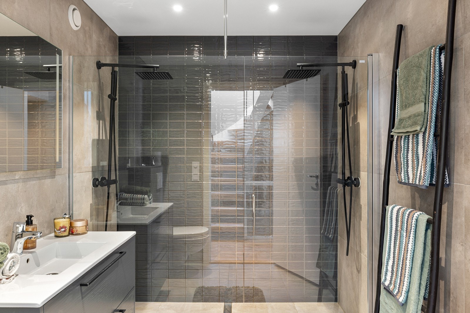 Badet har en praktisk dusjsone med glassvegger og 2 takdusjer, som gir et luftig og eksklusivt preg. Galleribilde