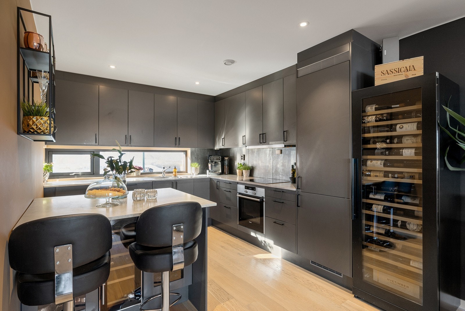 I 2019 ble det etablert en praktisk kjøkkenøy med sitteplass og integrert vinskap, noe som gir både ekstra oppbevaring og en sosial sone i rommet. Galleribilde