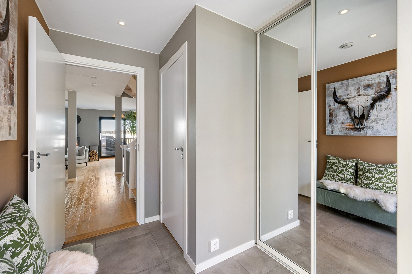 Entreen gir et godt førsteinntrykk av boligen med en lys og innbydende atmosfære, med flislagt gulv og behagelig gulvvarme. Skyvedørsgarderobe med speilfronter, som gir god plass til yttertøy, sko og tilbehør. Galleribilde