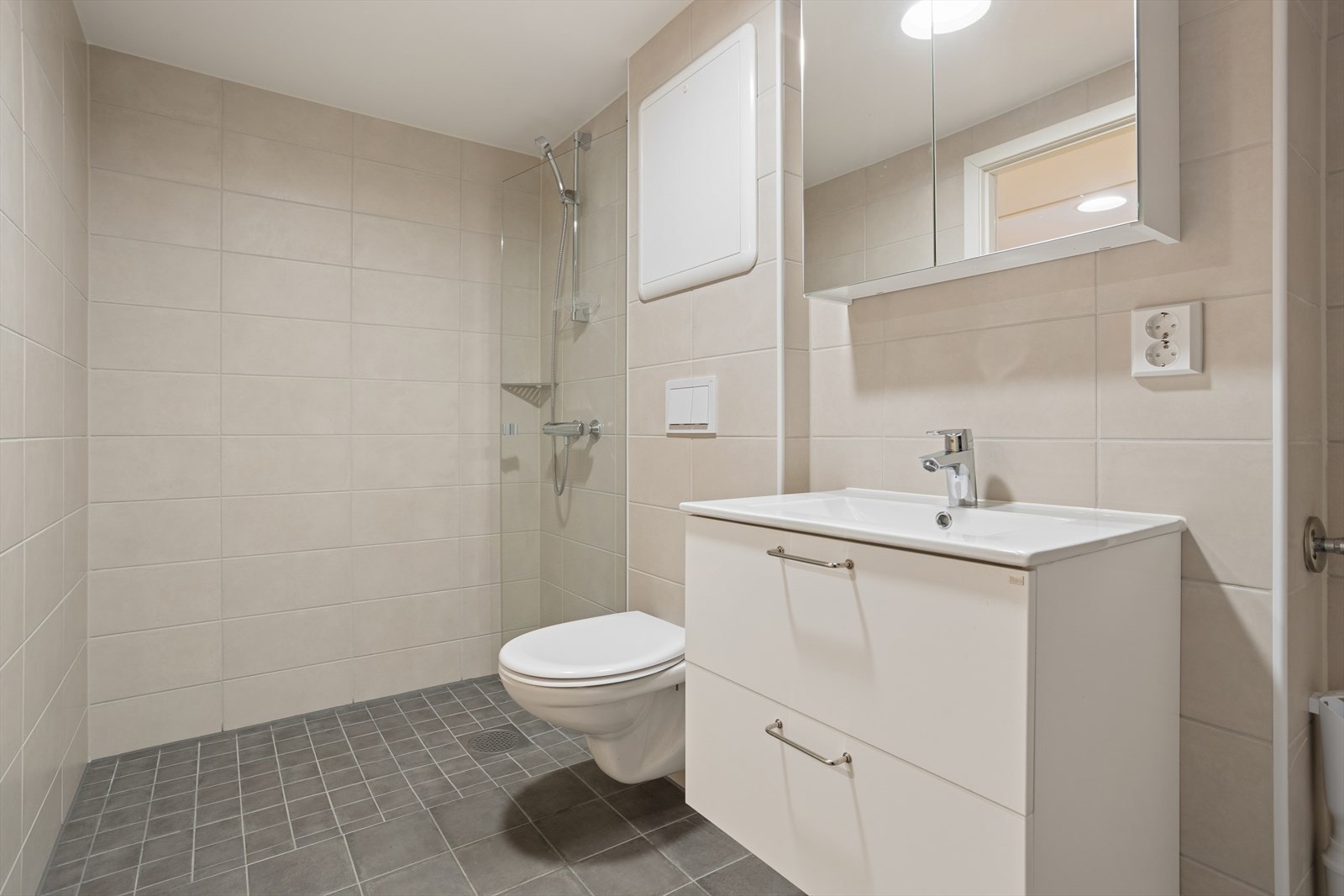 Baderommet har dusj, veggholdt wc og innredning, samt plass for vaskemaskin. Galleribilde