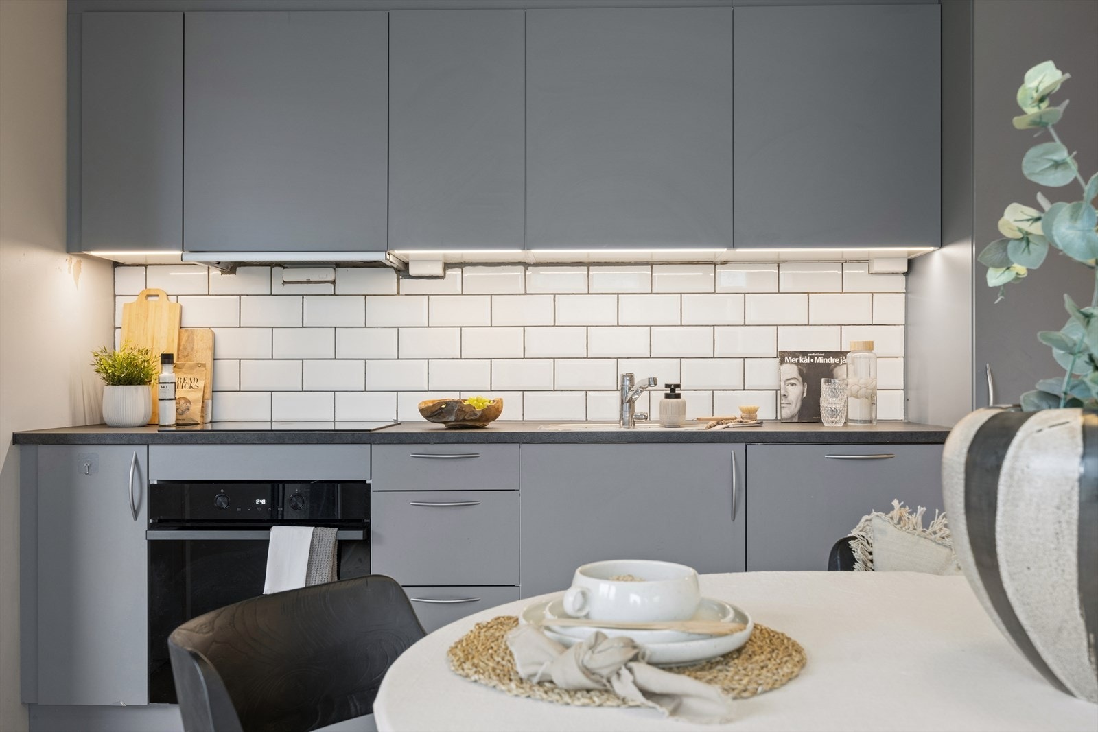 Kjøkkeninnredning fra Designa med slette fronter, laminert benkeplate og integrerte hvitevarer. Galleribilde