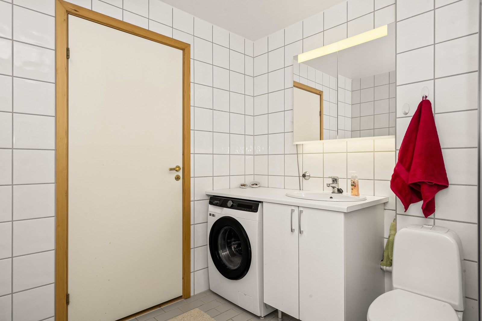 Praktisk innredning med servant og opplegg for vaskemaskin. Galleribilde