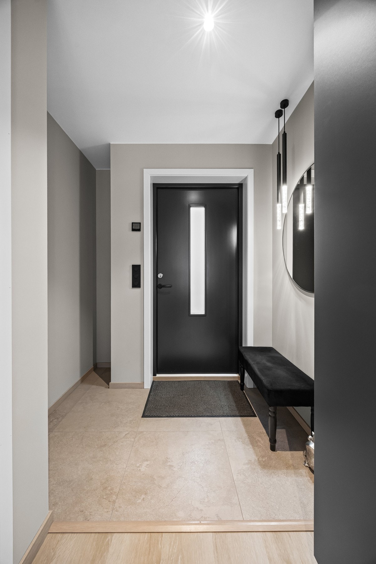 Du kommer inn i em moderne entrè innredet med sittebenk og speil. Galleribilde