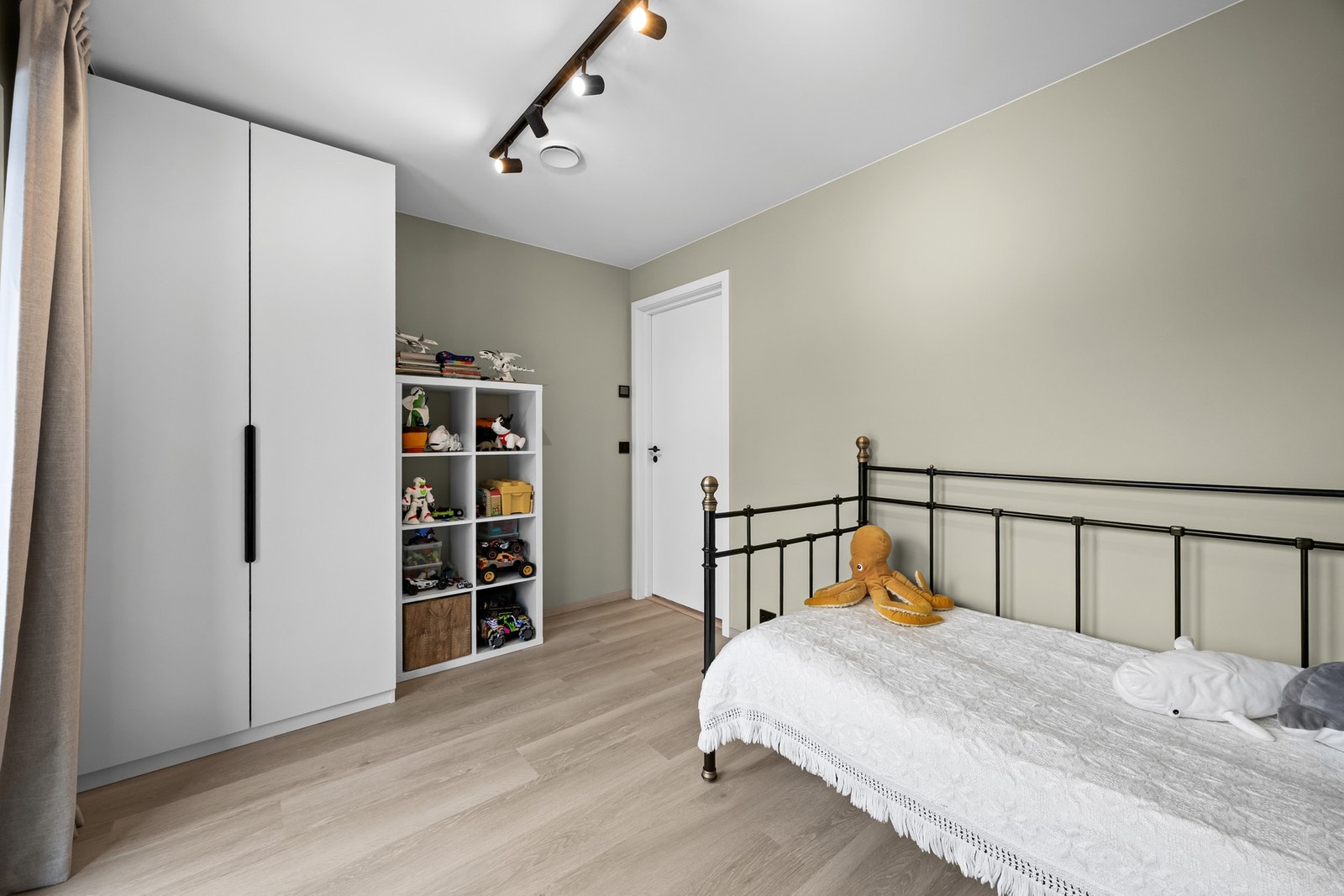 Innredet med enkeltseng, nattbord, kommode, garderobeskap og hyller til leker og bøker. Galleribilde