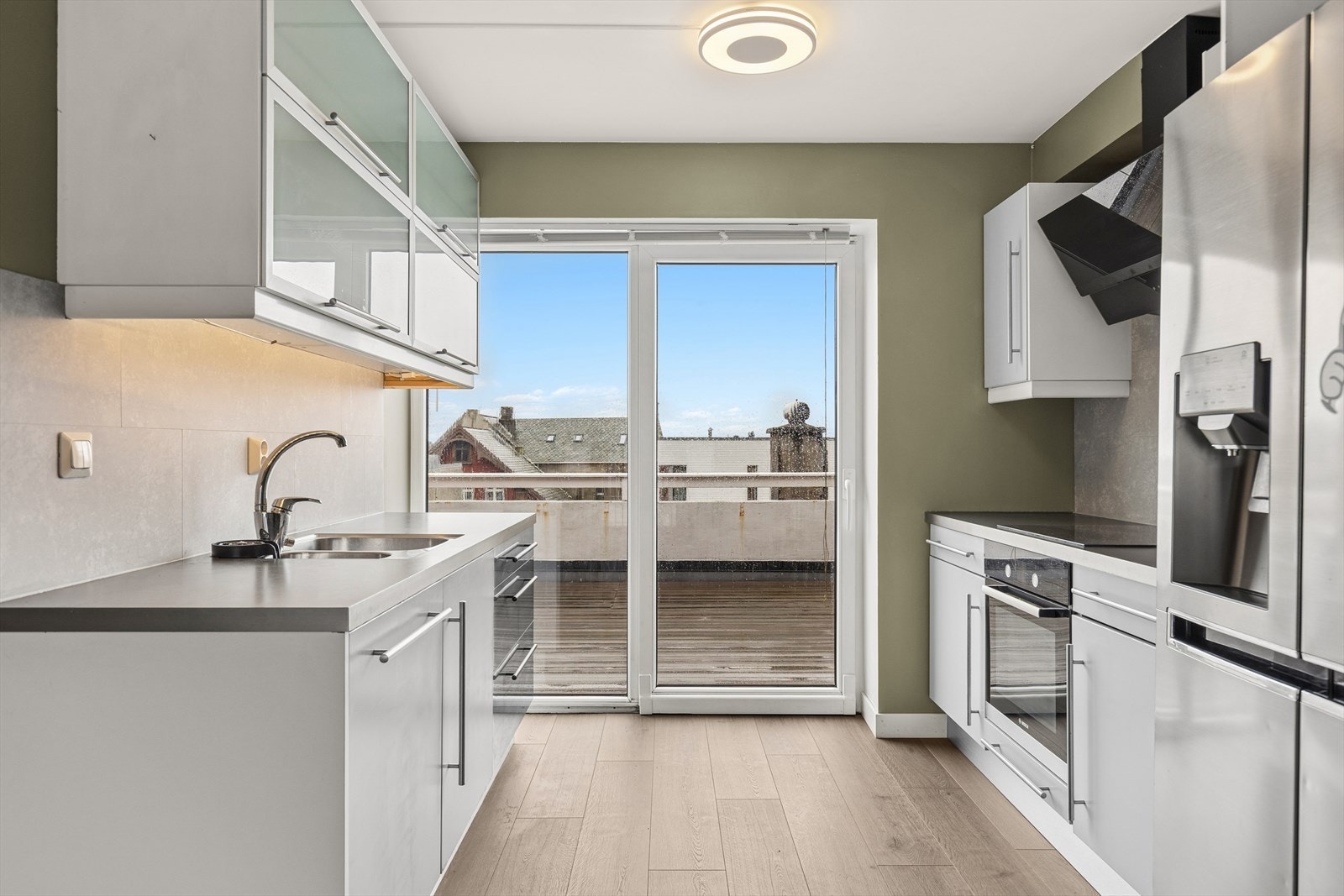 Moderne kjøkken med kjøl/fryseskap, integrert oppvaskmaskin, platetopp og integrert stekeovn. Galleribilde